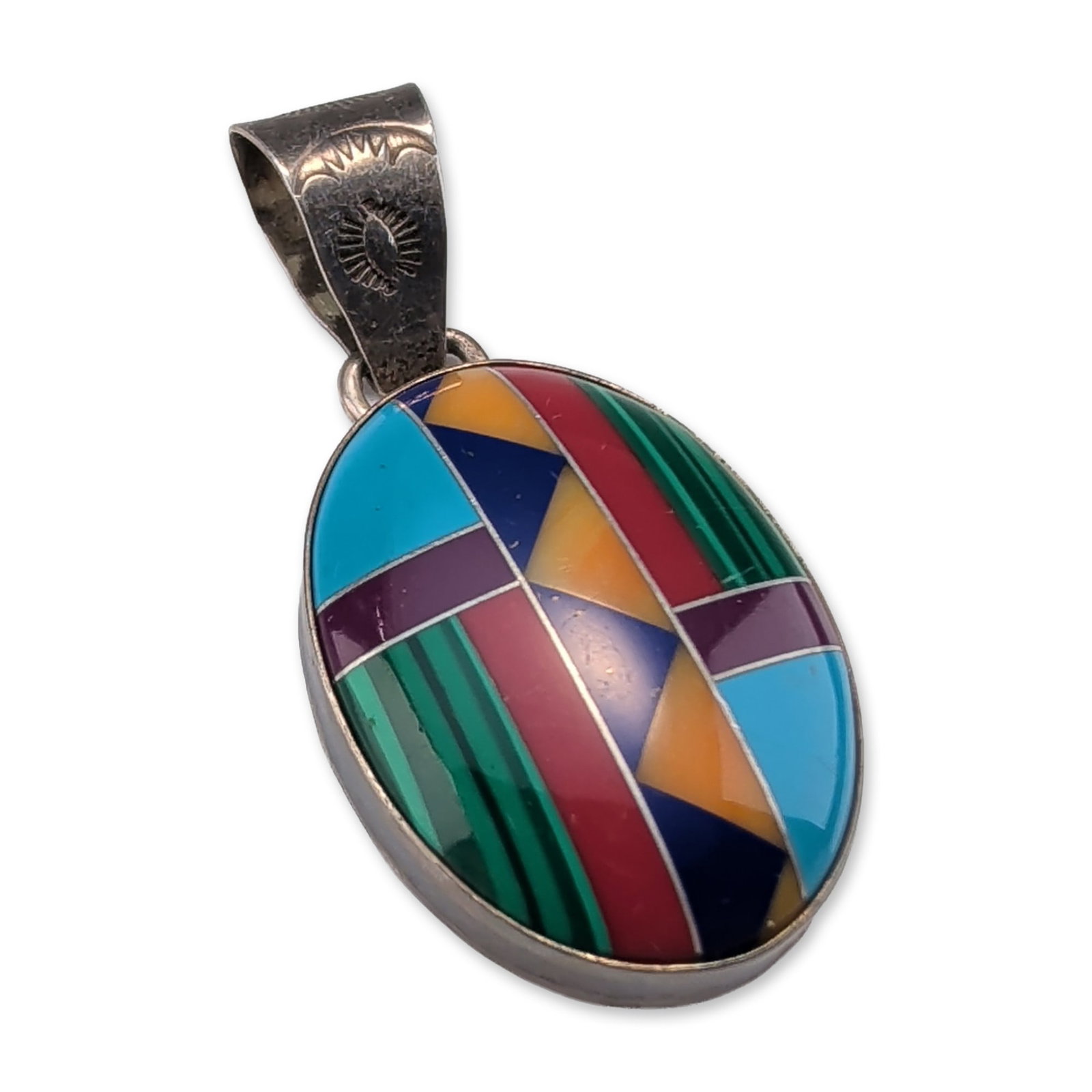 Southwestern Sterling Silver Multi-Stone Inlay Pendant: Southwestern pendant in sterling silver, featuring a multi-stone geometric intarsia inlay including malachite, turquoise, lapis lazuli, sugilite, and spiny oyster shell. The oval form is suspended fro