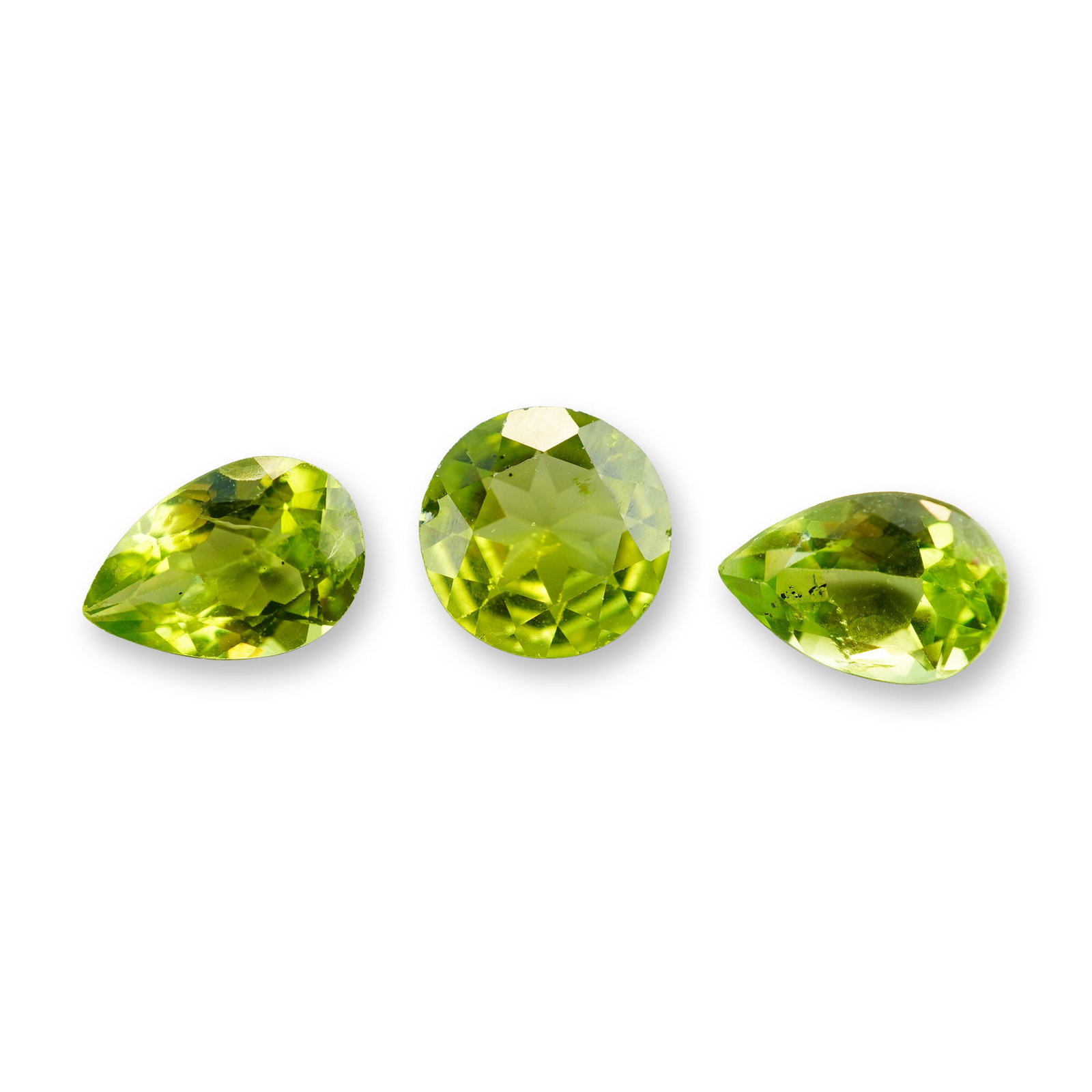 3pc Green Peridot Round and Pear Shape Stones: Loose faceted gemstone, documented as an Imperial pear shape sapphire. The stone appears to be a sapphire of light peachy-orange or champagne hue, featuring pear-cut brilliant-style faceting with shar