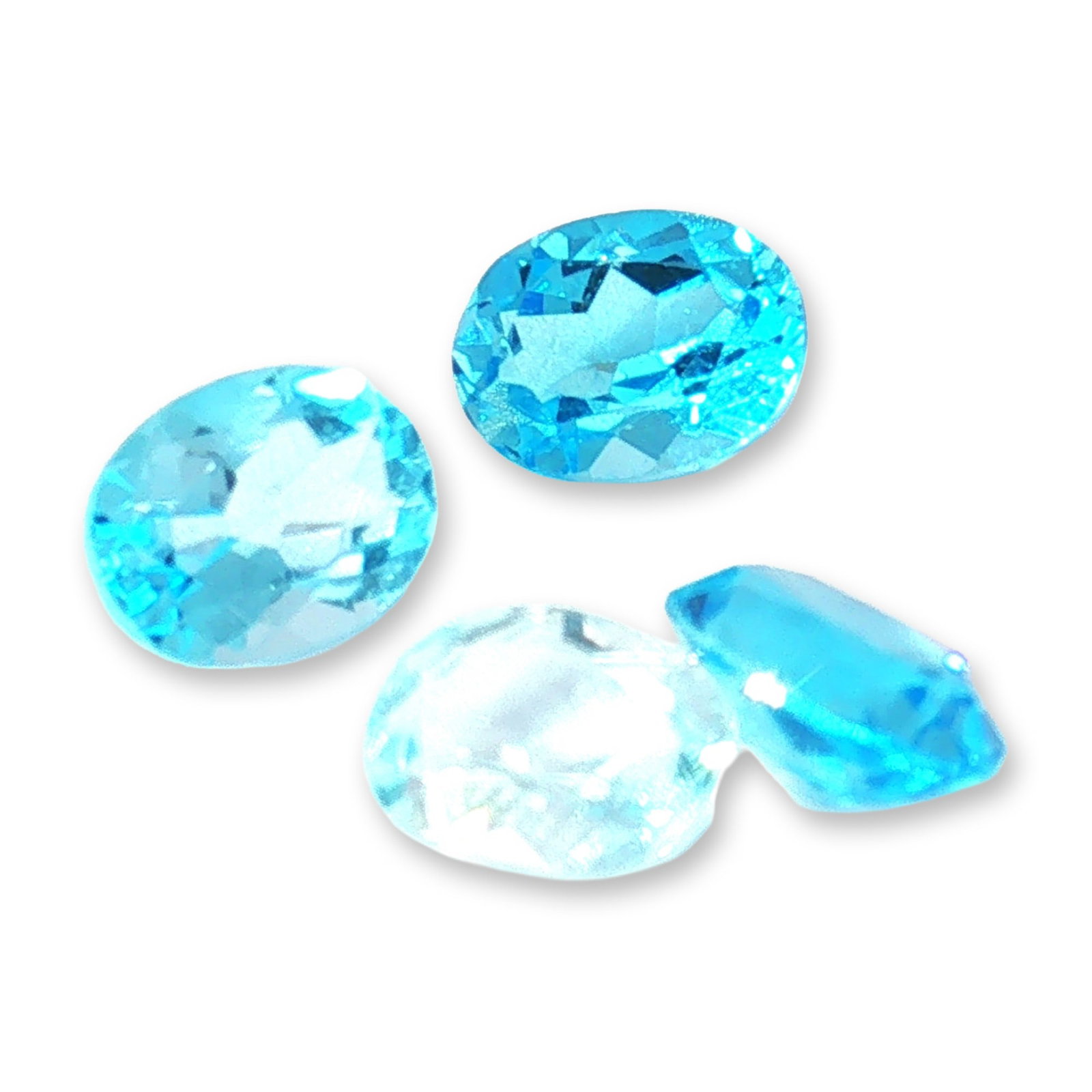 4pc Oval Blue Topaz Gemstones: Trio of loose faceted gemstones appearing to be rubies, featuring a vibrant purplish-red hue. The collection includes three distinct cuts: one round-cut, one cushion-cut, and one oval-cut gemstone. Ea