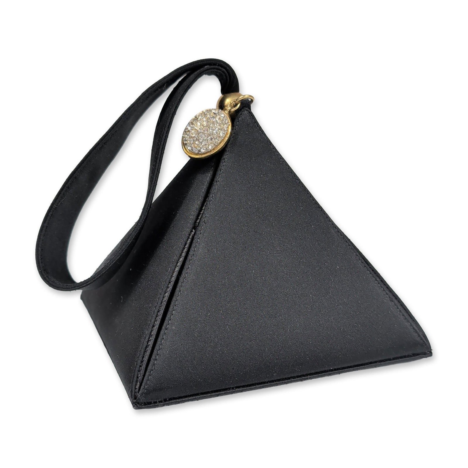 Carey Adina NYC Black Satin Pyramid Wristlet Bag: Pyramid-form evening wristlet bag in black satin. The bag features a three-sided tetrahedron shape constructed with a square base fitted with four gold-tone metal protective feet. A matching satin wri