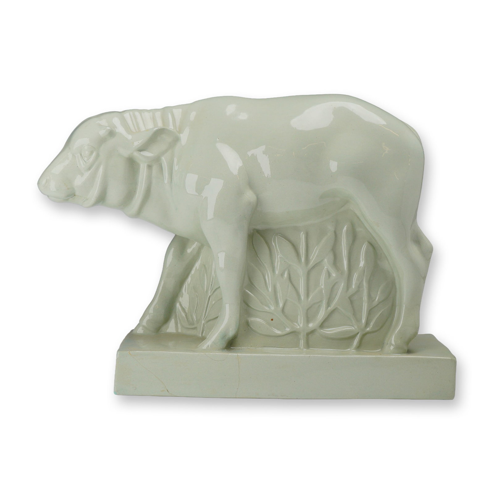 Wedgwood by John Skeaping Celadon Glazed Buffalo Figure: This Art Deco ceramic figure depicts a stylized buffalo standing against a backdrop of relief-molded foliage on an integrated rectangular plinth base. The piece is finished in a uniform celadon green 