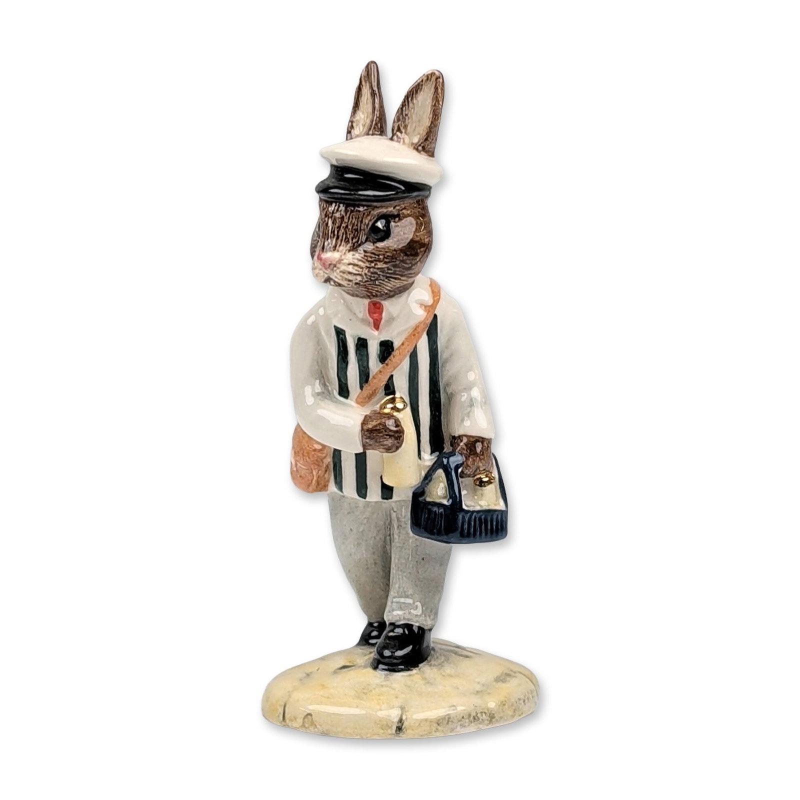 Royal Doulton Milkman Bunnykins DB 125 Figurine: Royal Doulton ceramic figurine, Milkman Bunnykins, model DB 125. Glazed hand-painted ceramic figure depicting a rabbit character in a black and white striped shirt, red necktie, gray trousers, and whi