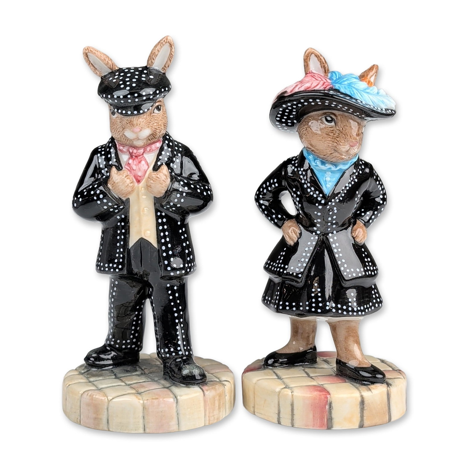 2pc Royal Doulton Bunnykins Pearly King and Queen Figurines: Royal Doulton, England. A pair of hand-decorated glazed ceramic figurines from the Bunnykins series, titled Pearly King (DB 411) and Pearly Queen (DB 412). Each figure depicts an anthropomorphic rabbi