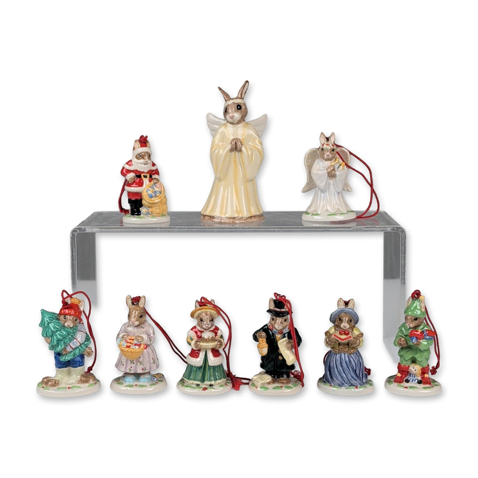 9pc Royal Doulton Bunnykins Christmas Figurine and Ornaments: Royal Doulton, England. Collection of nine Bunnykins holiday-themed figurines and ornaments in glazed porcelain. The group features anthropomorphic rabbits in festive attire, comprising one larger ang