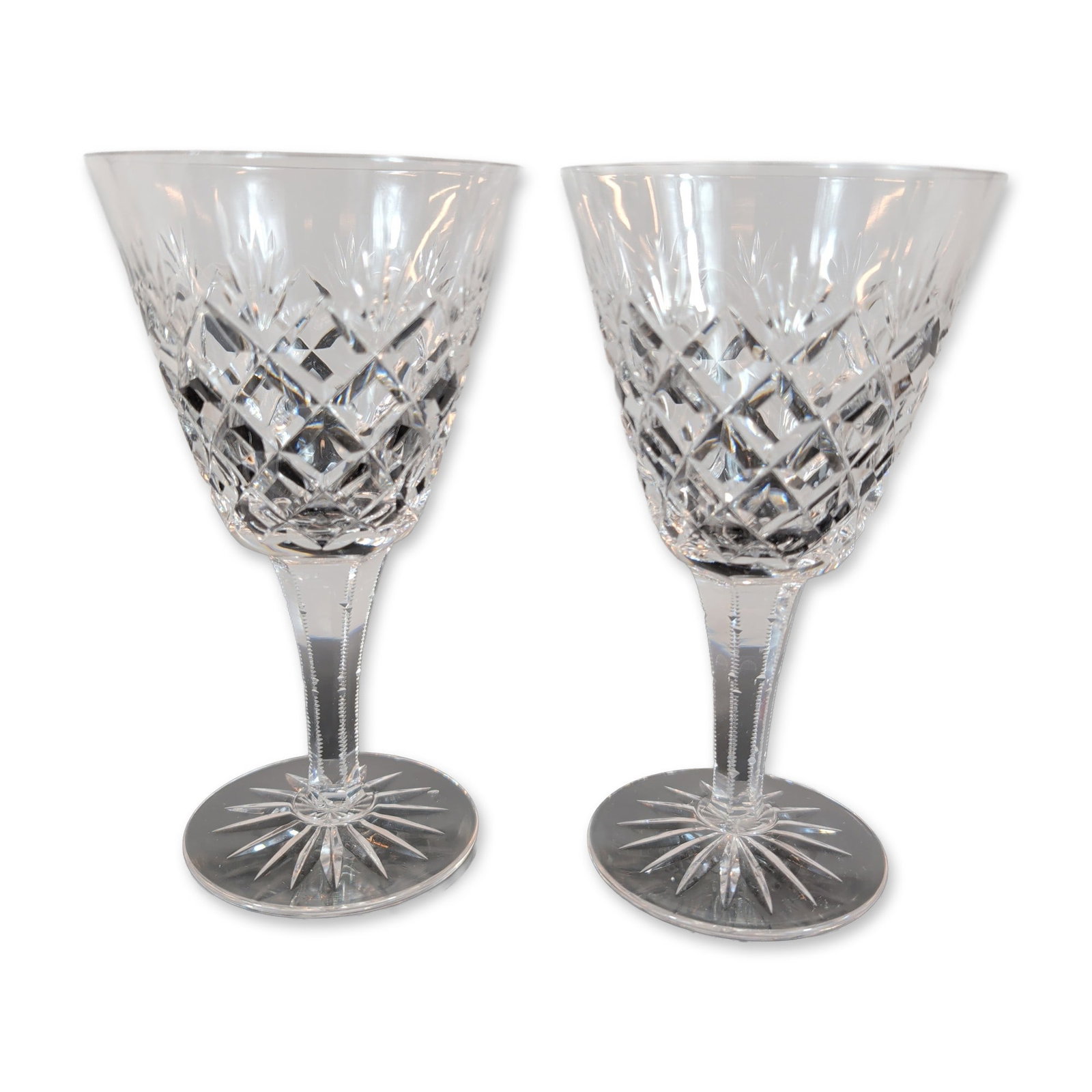 Pair of Cut Crystal Wine Glasses: Pair of lead crystal wine glasses. The bowls feature deep diamond cross-hatch cutting below a border of vertical wedge cuts. Each glass is supported by a faceted hexagonal stem with notched edges,