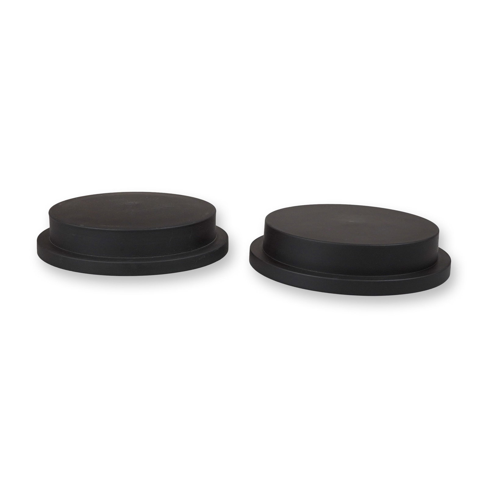 A Pair of Black Basalt Round Tiered Plinths: A pair of circular display plinths crafted from matte black basalt. Each stand features a tiered construction consisting of a wider bottom flange and a slightly narrower, flat-topped upper platform.