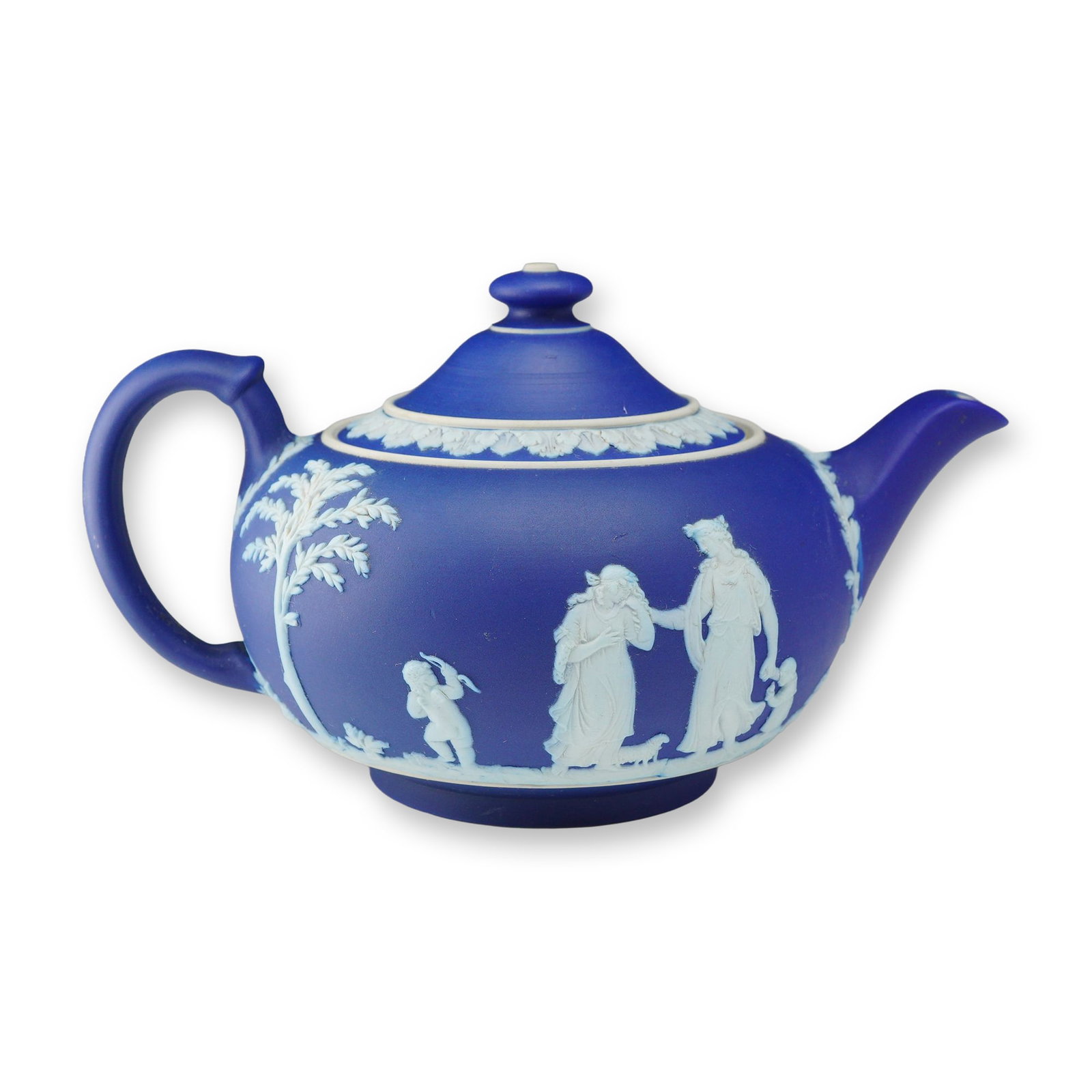 Wedgwood Cobalt Blue Jasperware Lidded Teapot: A Wedgwood cobalt blue jasperware lidded teapot featuring sprigged white bas-relief neoclassical decoration. The globular body is ornamented with classical scenes depicting figures in draped