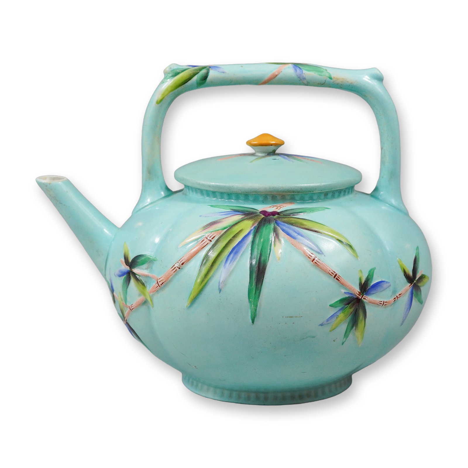 Wedgwood Majolica Bamboo Pattern Tropical Teapot: A Wedgwood majolica earthenware teapot featuring the Bamboo pattern, characterized by a vibrant turquoise blue ground and relief-molded tropical motifs. The vessel has a lobed, melon-shaped body decor
