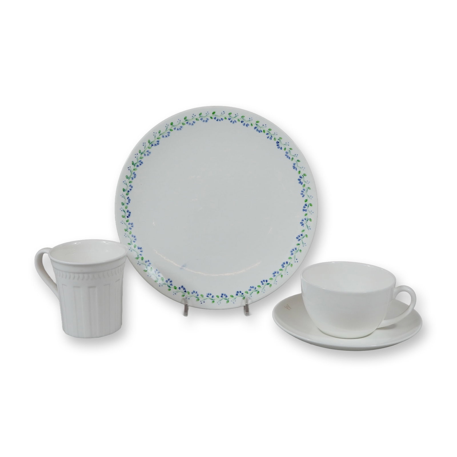 4pc Bone China Wedgwood Dishes: Dinner Plate, Teacup, Saucer, and Mug: This collection consists of four pieces of Wedgwood English bone china in various patterns. The grouping includes one mug in the Colosseum pattern, designed with white-on-white relief-molded vertical 