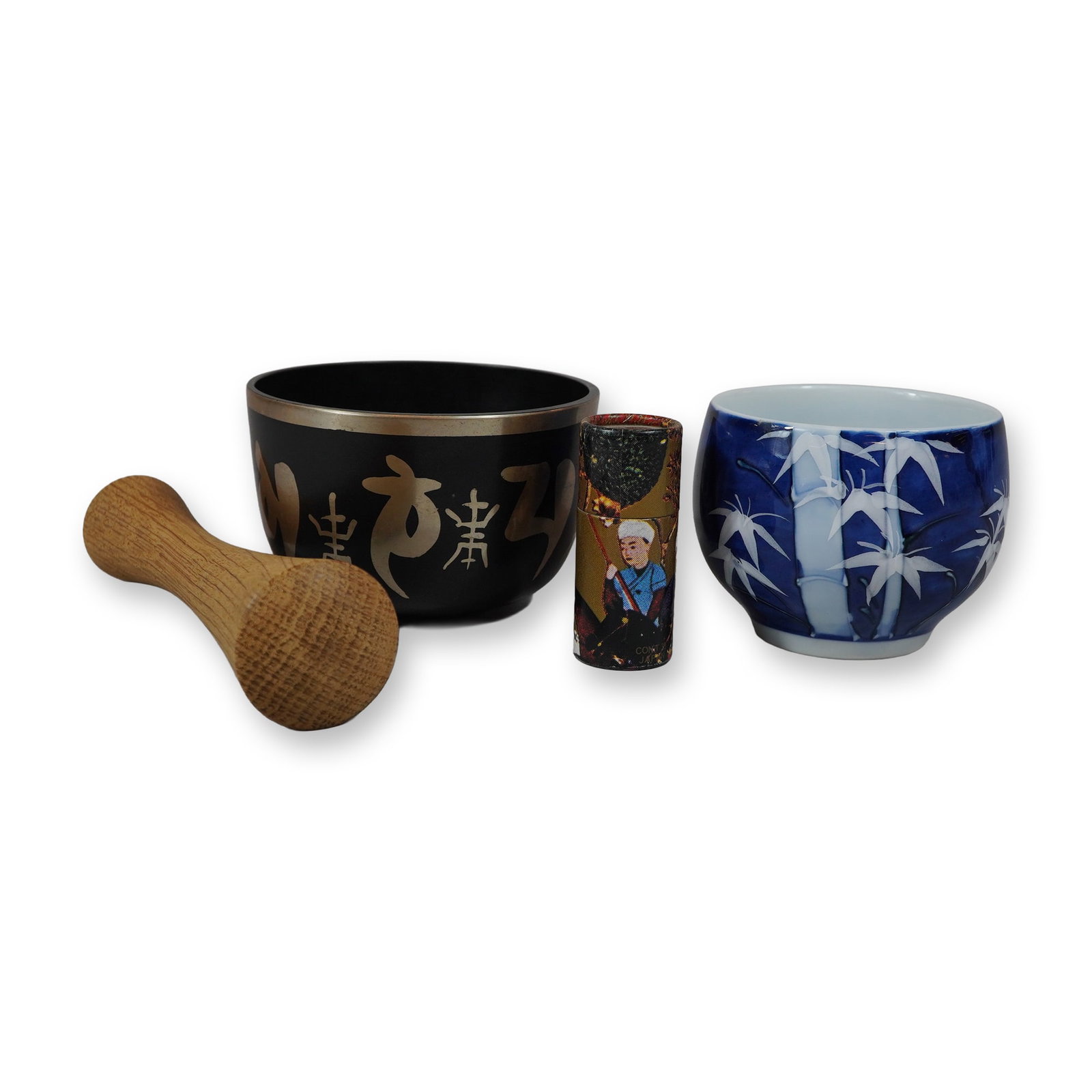 3pc Asian Items Including a Tibetan Singing Bowl, Japanese Porcelain Bowl and Japanese Matches: This collection of three Asian decorative and ritual objects consists of one Tibetan-style singing bowl with a wooden striker, one Japanese porcelain bowl, and one match striker holder with matches. T