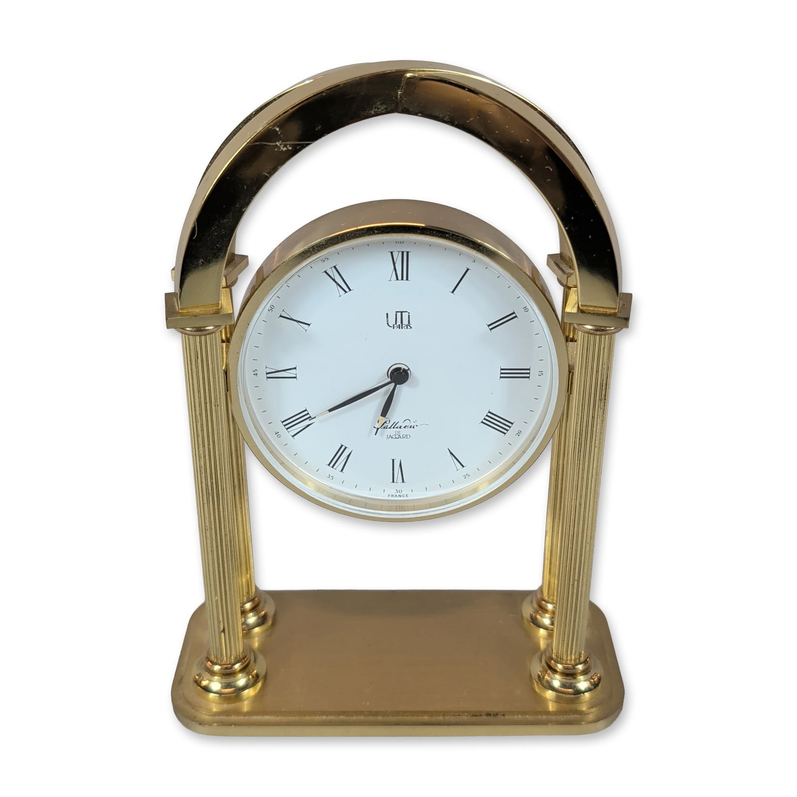 UTI Paris Palladio Gilt Metal Desk Clock: French desk clock in gilt metal by UTI Paris, Palladio de Jaccard model, featuring a circular timepiece suspended between two fluted columns on a rectangular base. The white dial is printed with black