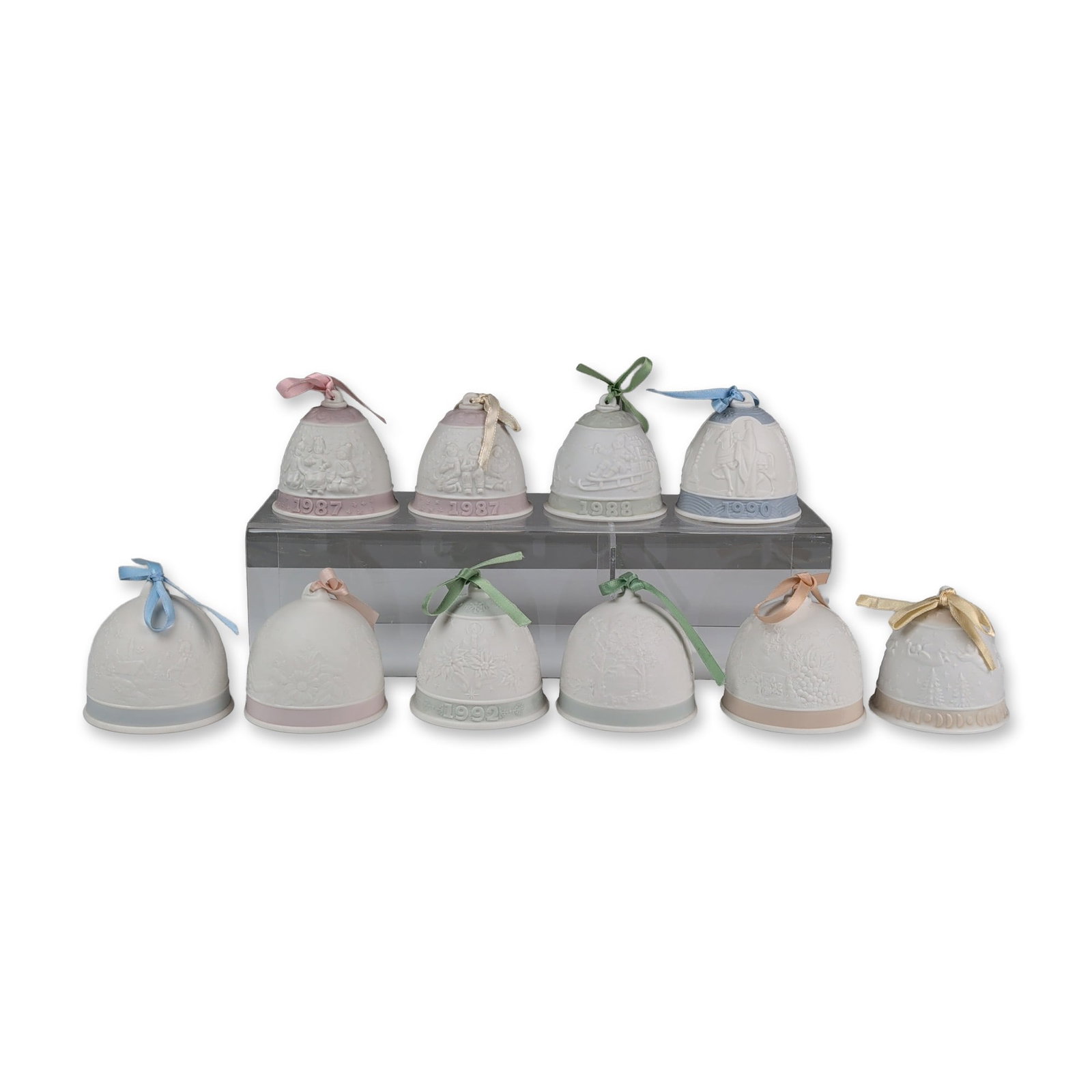 10pc Lladro Bisque Porcelain Christmas and Seasonal Bells: Collection of ten Lladro Christmas-themed bisque porcelain bells featuring various holiday relief scenes including children in winter clothing, sledding, nativity figures, poinsettias, and snowy lands