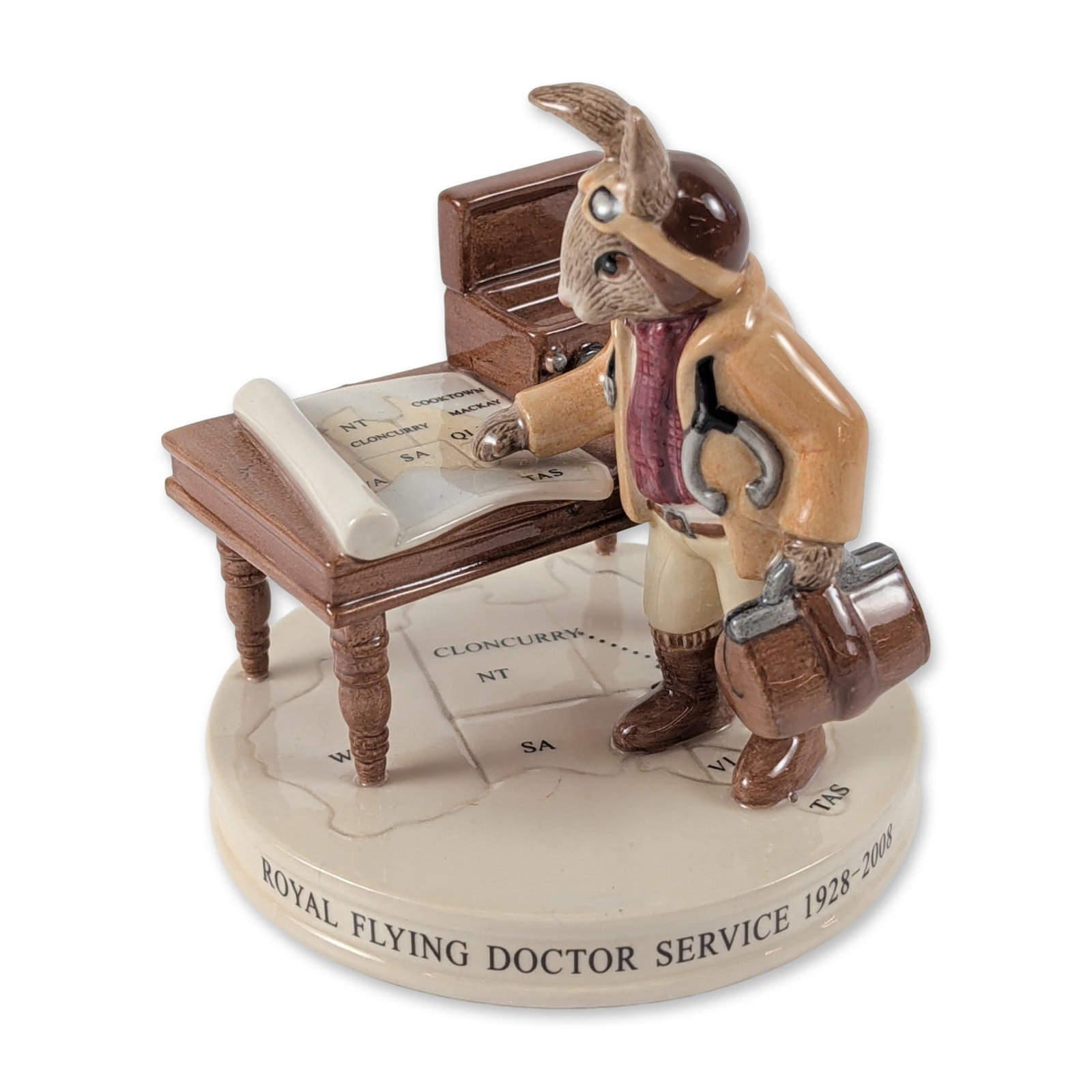Royal Doulton Bunnykins Flying Doctor DB 468 Figurine: Royal Doulton. Character figurine in glazed porcelain titled Flying Doctor, model DB 468. The piece depicts a rabbit dressed as a pilot doctor with a stethoscope and medical bag, positioned beside a d