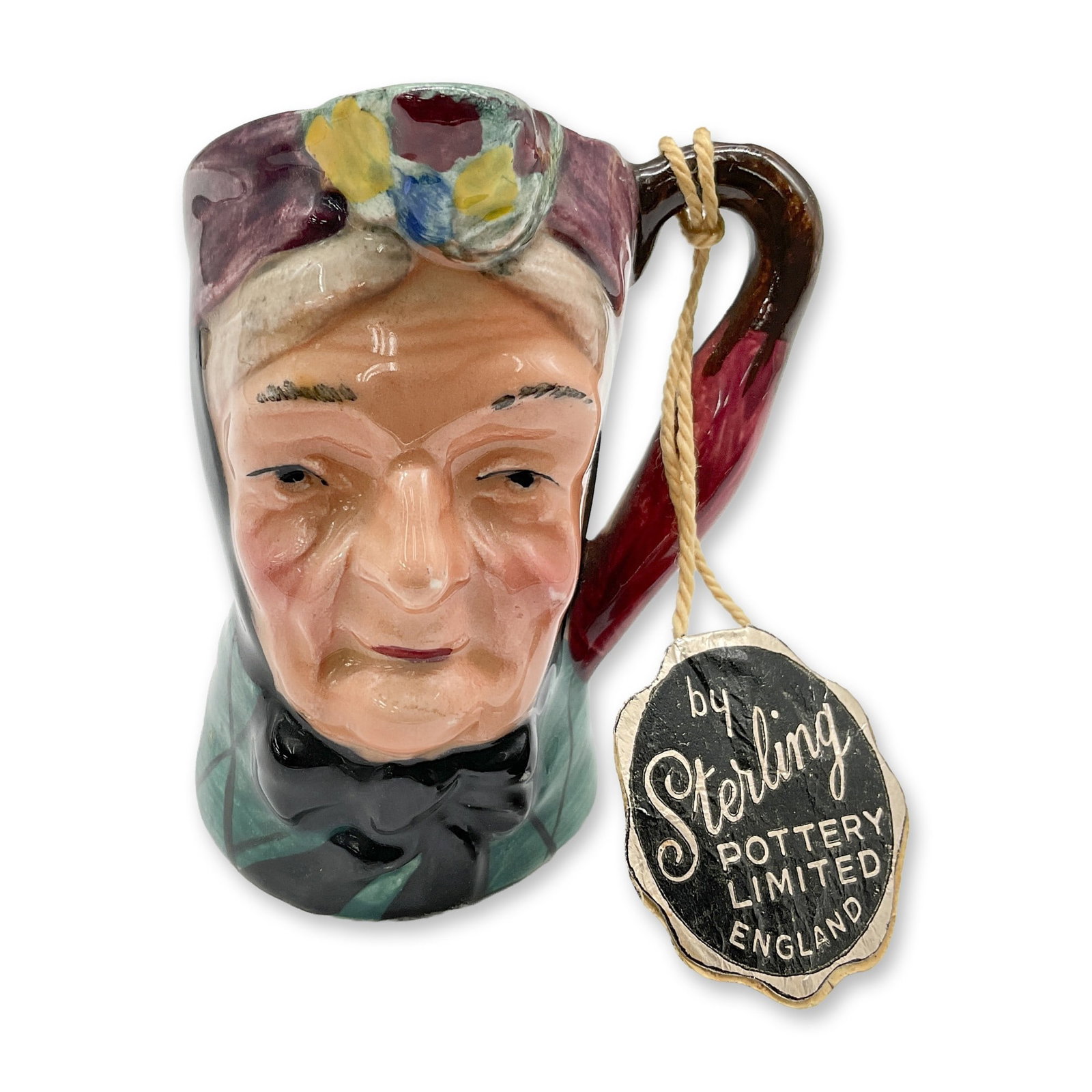 Sterling Pottery Porcelain Character Jug, Granny: Part of the Ridgways Old English Character Jugs. Glossy, hand painted figure, colored in purple, black and blue. Sterling Pottery backstamp and tag. Dimensions: 2.25"L x 2.25"W x 3"H Date or Era: