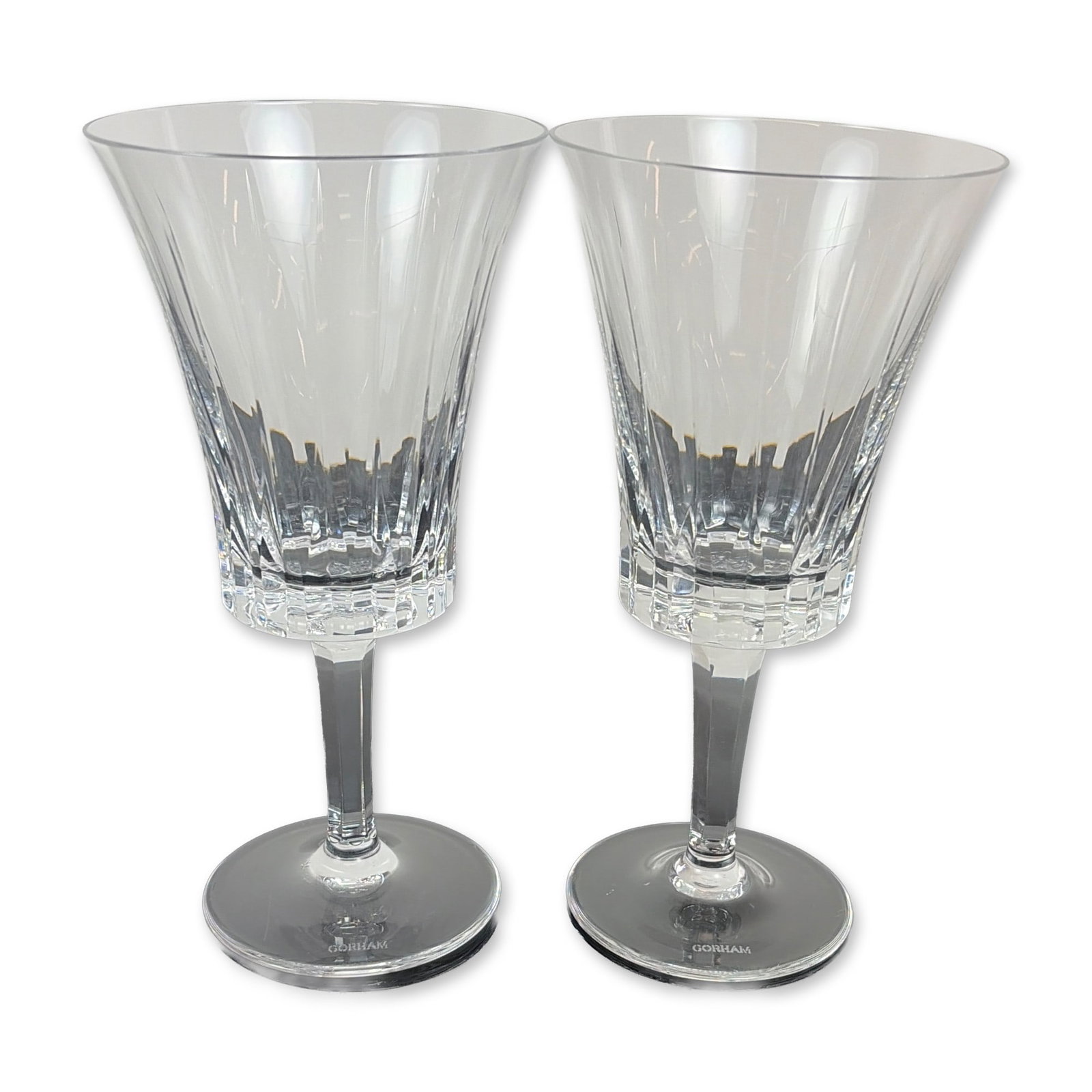 Pair of Gorham Richelieu-Rondo Water Goblets: Each vessel features a trumpet-shaped flared bowl decorated with vertical fluted cuts above a band of deep crisscross diamond accents. The stems are faceted and taper toward a circular foot. The foot 