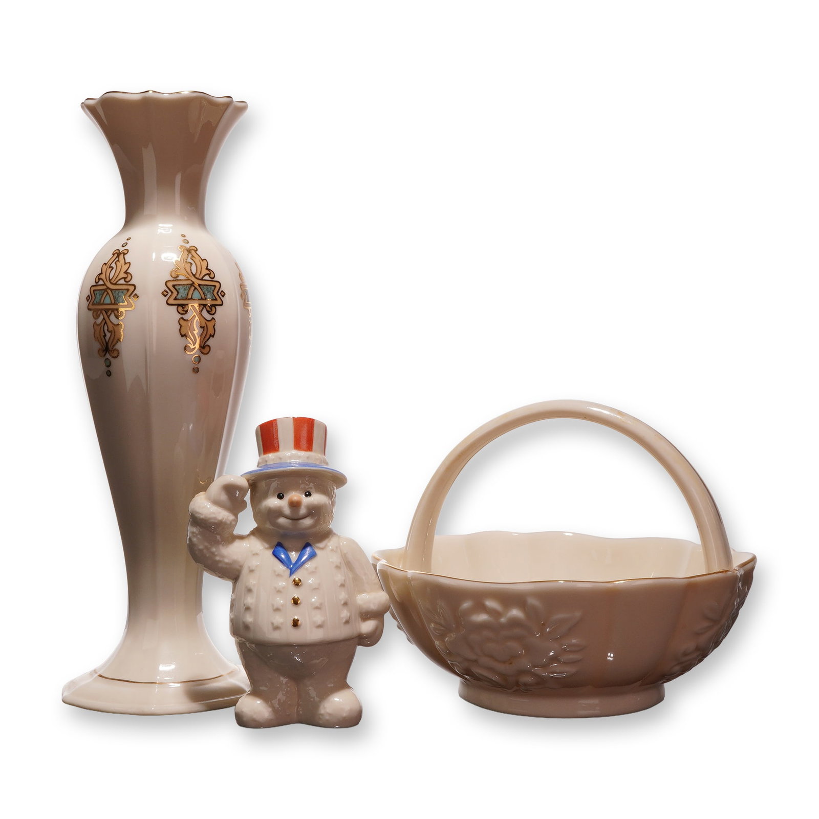 Three Lenox Ivory Porcelain Pieces including Catalan Bud Vase, Floral Basket, and Patriotic Snowman: This lot features three pieces of fine ivory porcelain from Lenox, all showcasing the manufacturer's signature cream-colored glaze and gold-tone accents. The first piece is a slender bud vase in the