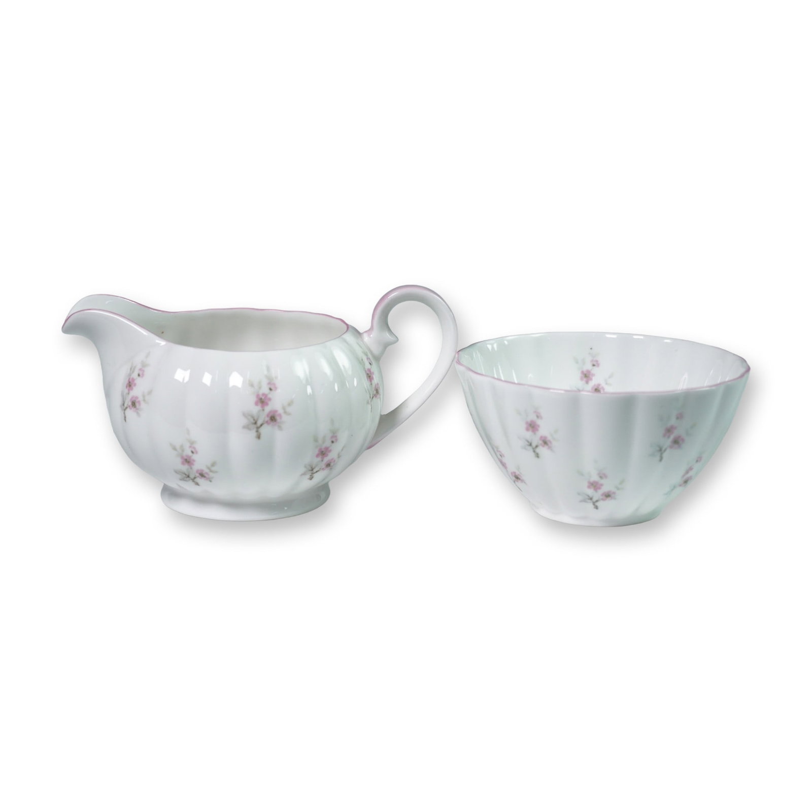 2pc Royal Tuscan Cream and Sugar Set, Pink Floral: Delicate bone china cream and sugar set by Royal Tuscan, featuring fluted white bodies adorned with petite pink floral sprays and soft pink trim. Both pieces are marked Royal Tuscan Fine Bone China, M