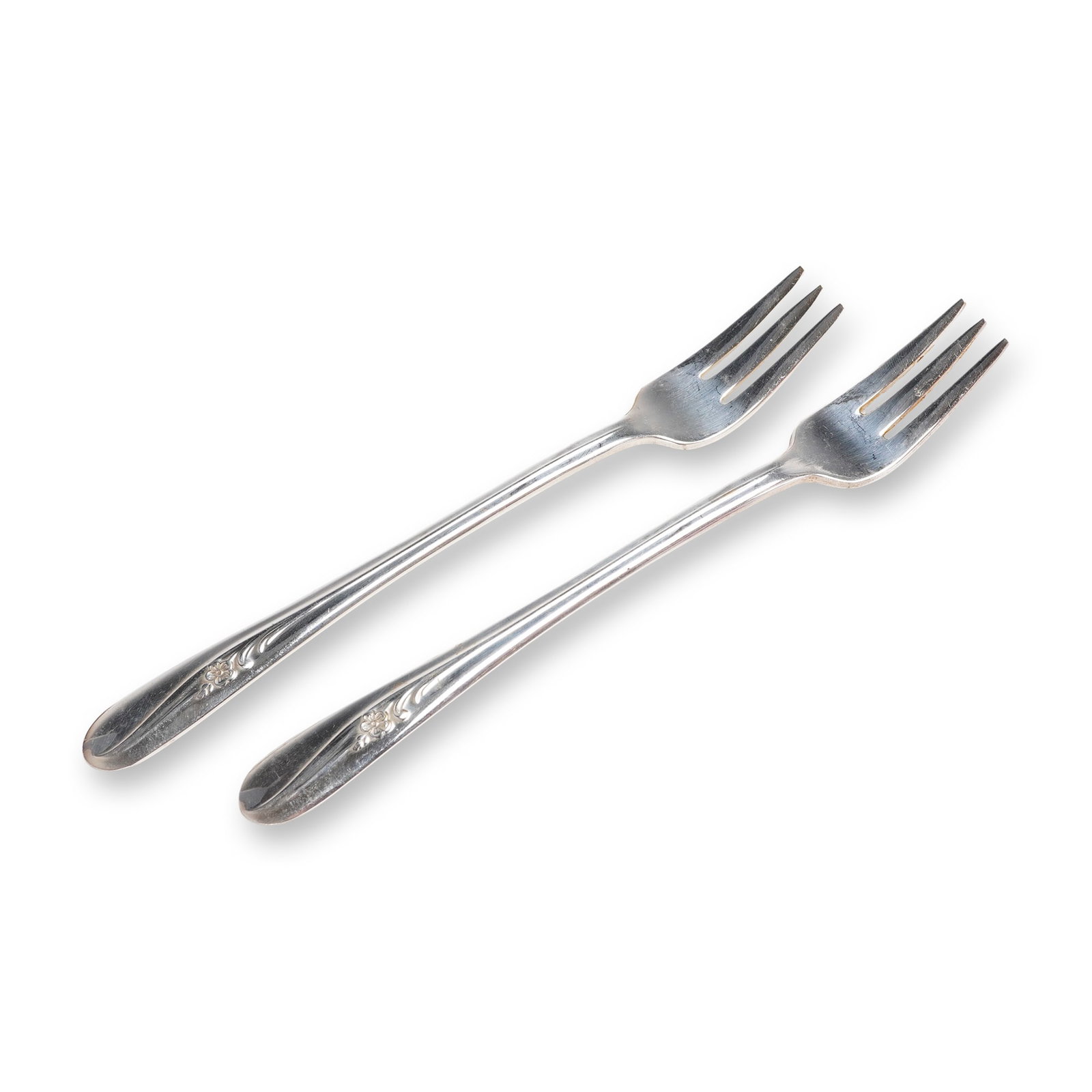 A Pair of Holmes & Tuttle Silverplate Meadow Flower Pattern Forks: A pair of silverplate dining forks by Holmes & Tuttle (H. & T. MFG. CO.) in the Meadow Flower pattern, dating to approximately 1940. This 2pc lot consists of two matching four-tine dining