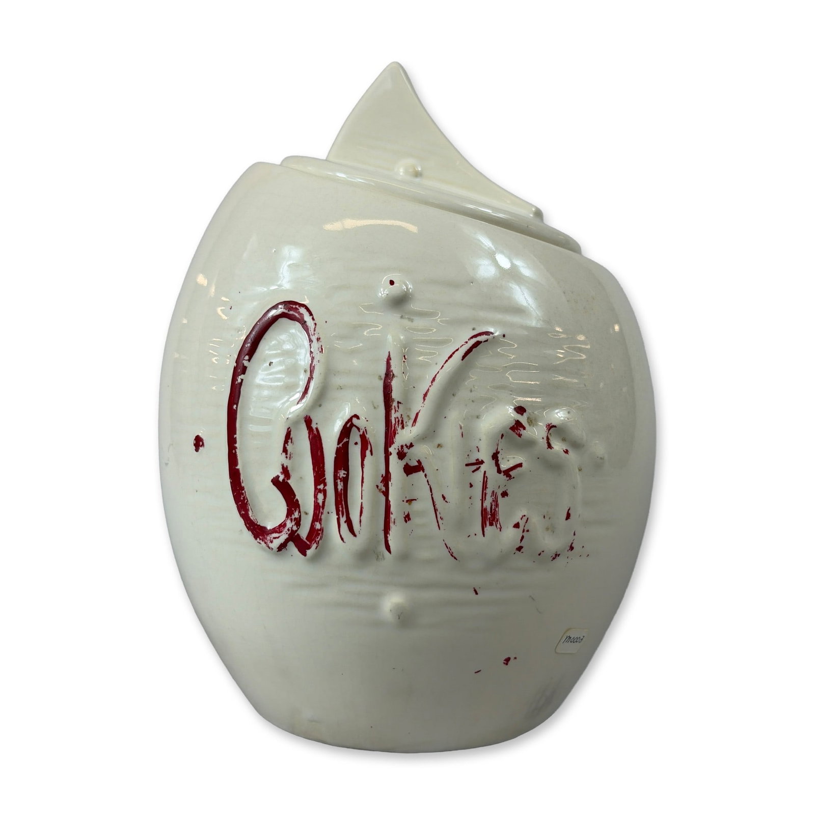 McCoy Ceramic Cookie Jar: Ceramic cookie jar in white glazed earthenware, featuring a matching lid with a stylized wedge handle and molded cursive Cookies lettering highlighted with red cold paint. The underside of the base sh