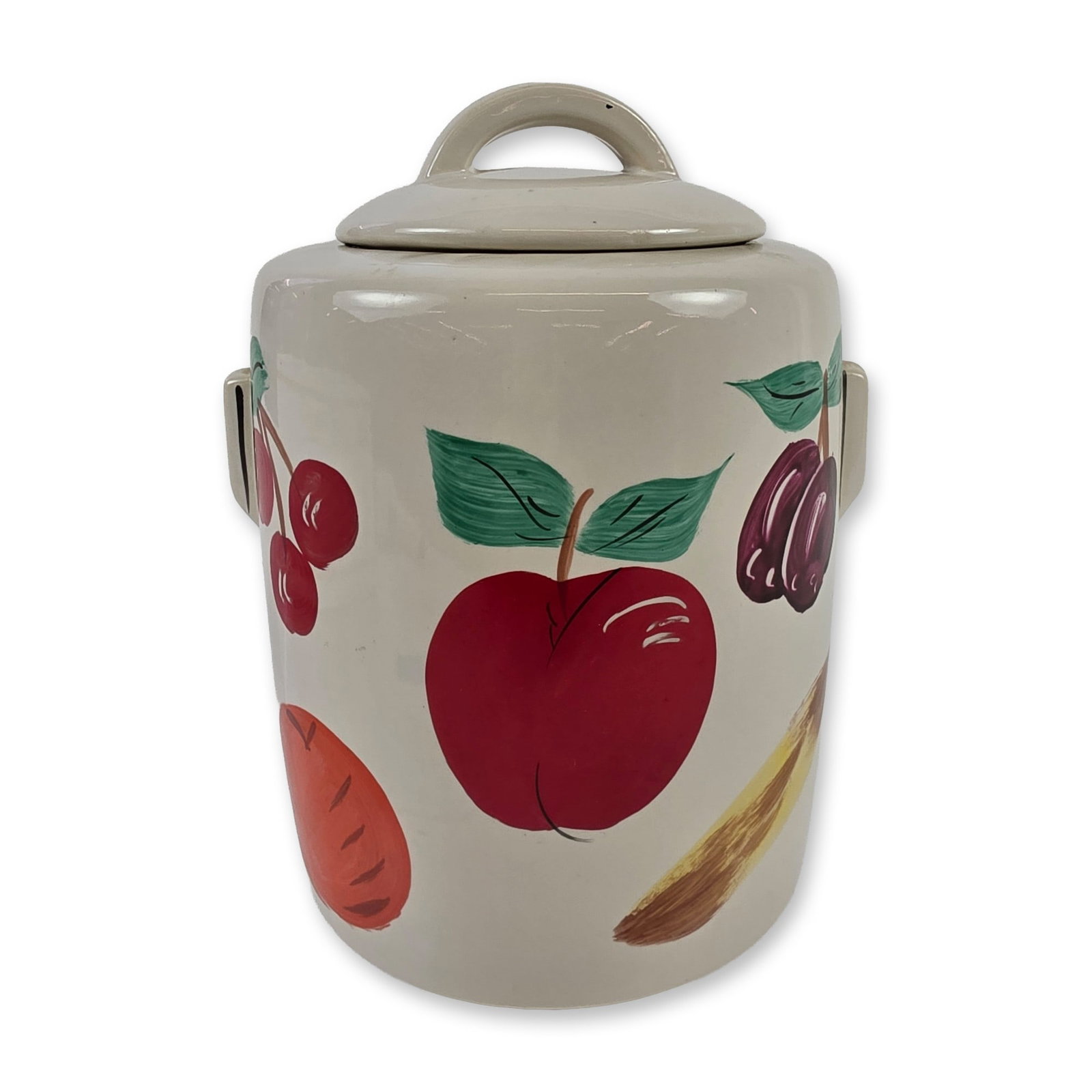 McCoy Ceramic Fruit Cookie Jar: Cookie jar in glazed earthenware, featuring a cylindrical body with two lug handles and a matching domed lid with a hoop-style handle. The exterior is decorated with hand-painted fruit and vegetable