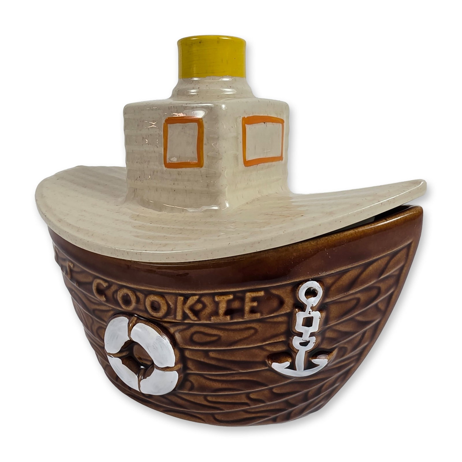 McCoy Ceramic Tugboat Cookie Jar: Mid-20th century ceramic cookie jar in the form of a tugboat. The two-part vessel features a dark brown glazed base with relief-molded wood grain texture, decorated with a lifebuoy, an anchor, and the