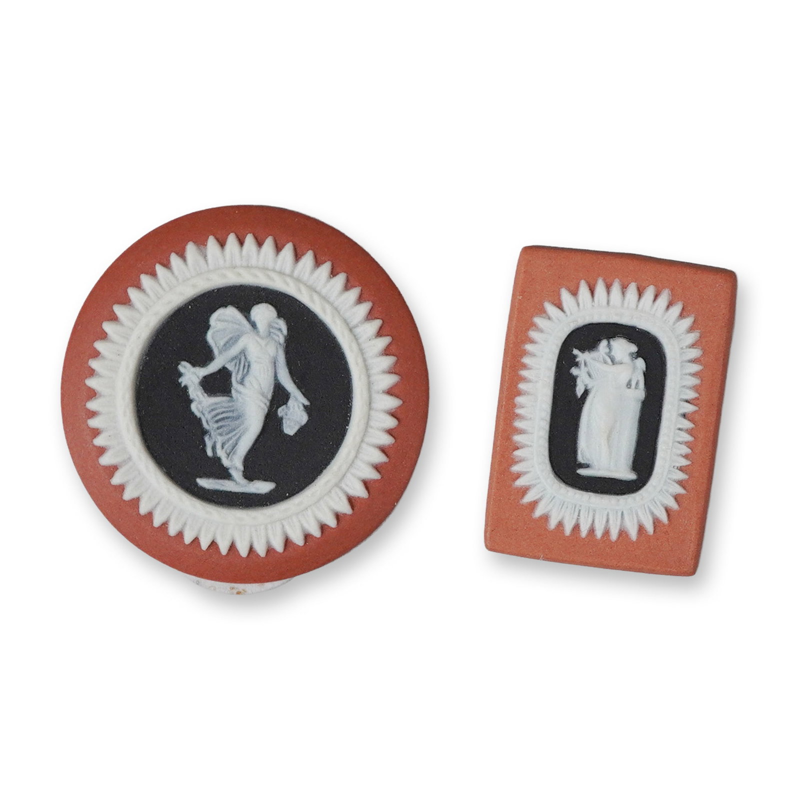 2pc Wedgwood Tri-Color Jasperware Medallions: This pair of Wedgwood tri-color jasperware medallions features a terracotta-colored stoneware ground with central black fields and white bas-relief decoration. The circular medallion depicts a