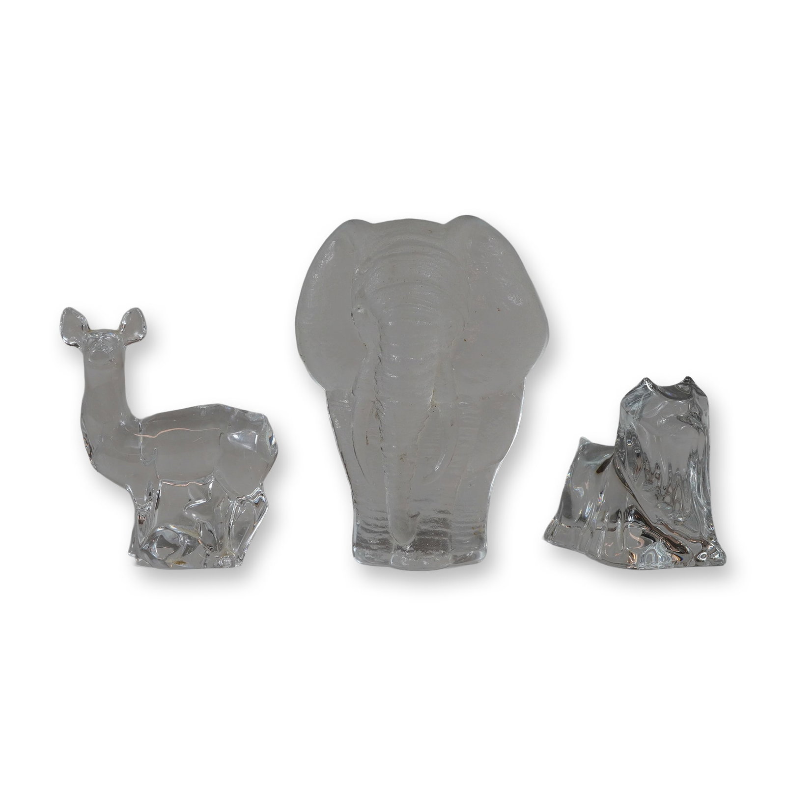 Group of Three Crystal Animal Figurines: Group of three crystal glass animal figurines, including an Orrefors deer, a Baccarat Yorkie dog, and a Mats Jonasson elephant. The stylized standing deer figurine in clear lead crystal by Orrefors