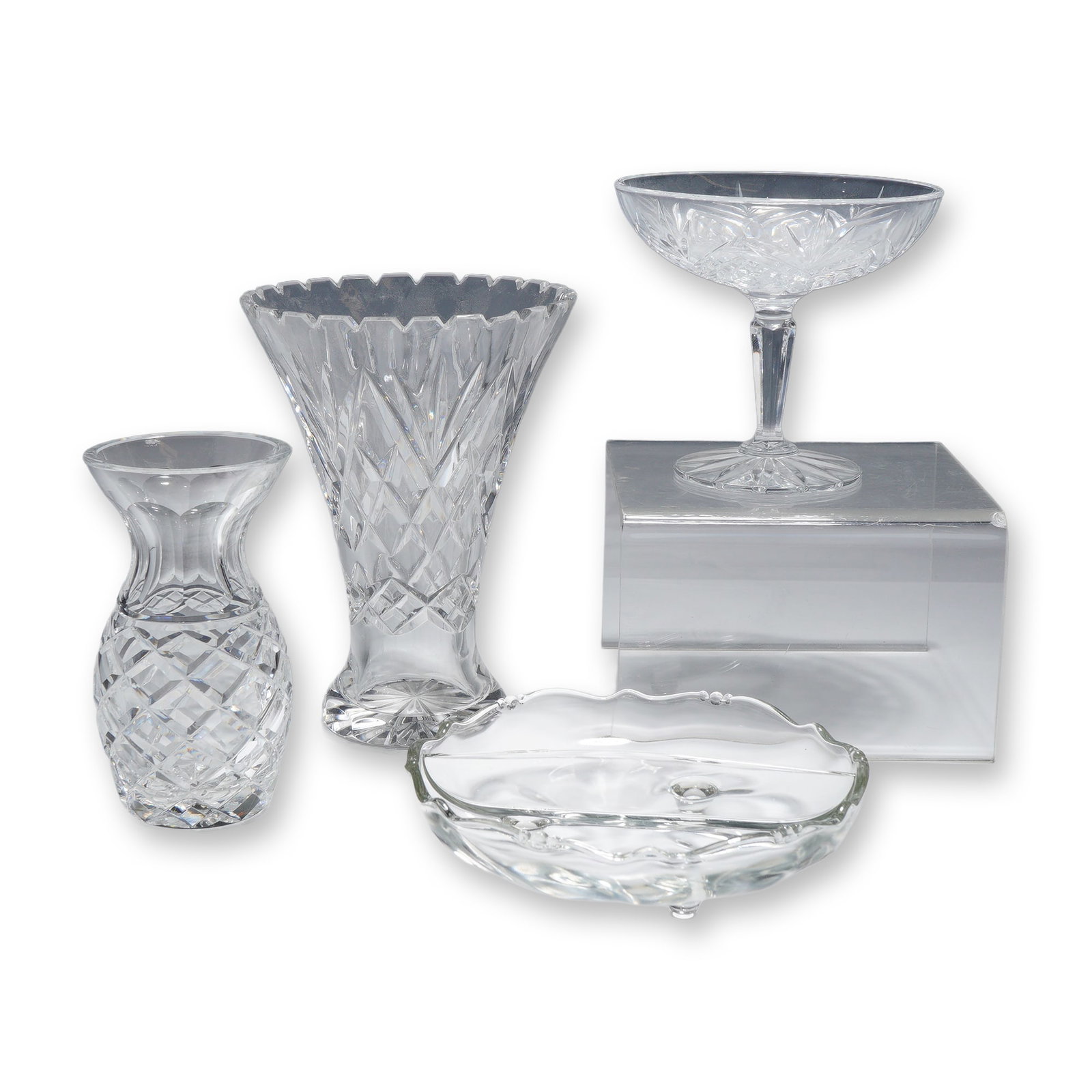 Four Piece Collection of Cut Crystal and Pressed Glass Tableware- Vases and Bowls: This collection consists of clear glass and crystal decorative items. The assortment includes a bud vase with a bulbous body and flared rim, featuring deep diamond cutting, a faceted neck, and a multi