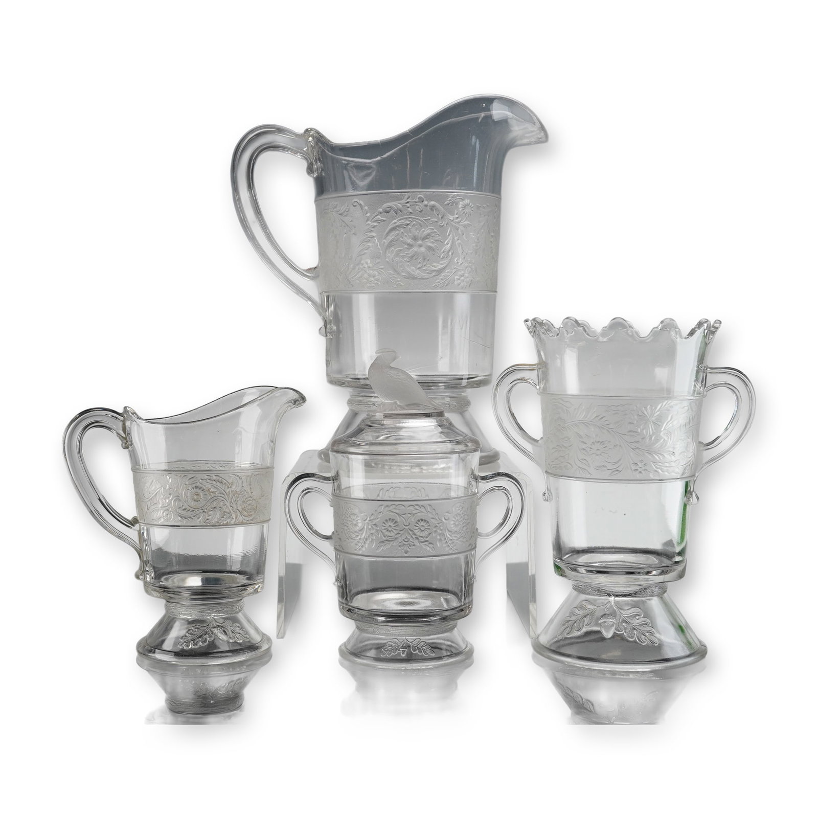 5 EAPG Flower Band Pattern Tableware Pieces: A collection of five pieces of Early American Pattern Glass (EAPG) tableware in the Flower Band pattern, circa 1870s-1880s. The lot consists of four vessels and one lid. The vessels include a large wa