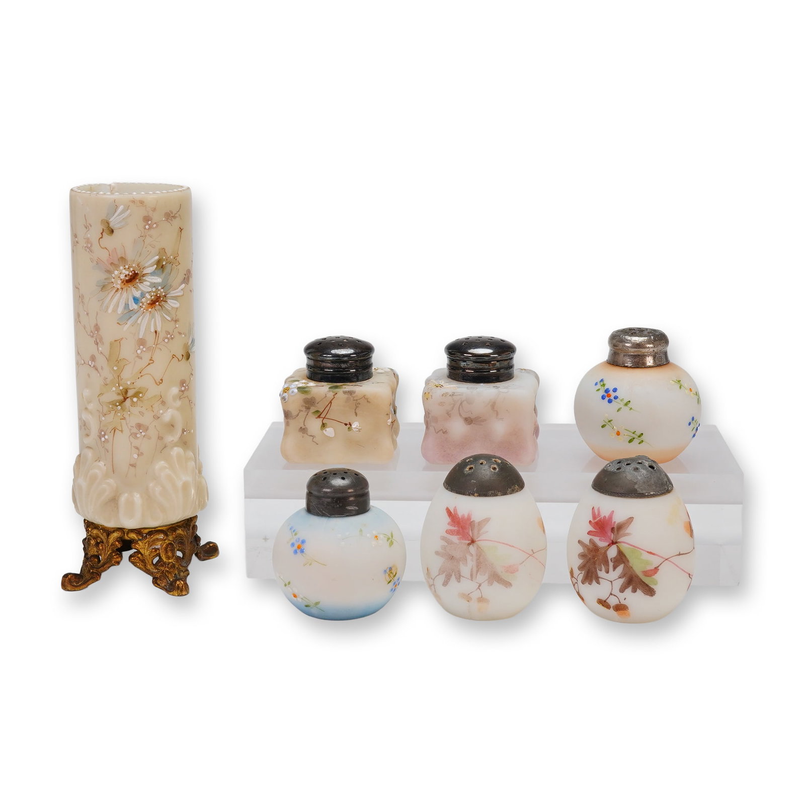 A Collection of Seven Hand-Painted Milk Glass Footed Vase and Salt Shakers: A collection of seven pieces of decorative milk glass, likely dating from the late 19th or early 20th century, comprising one footed vase or muffineer body and six assorted salt and pepper shakers.