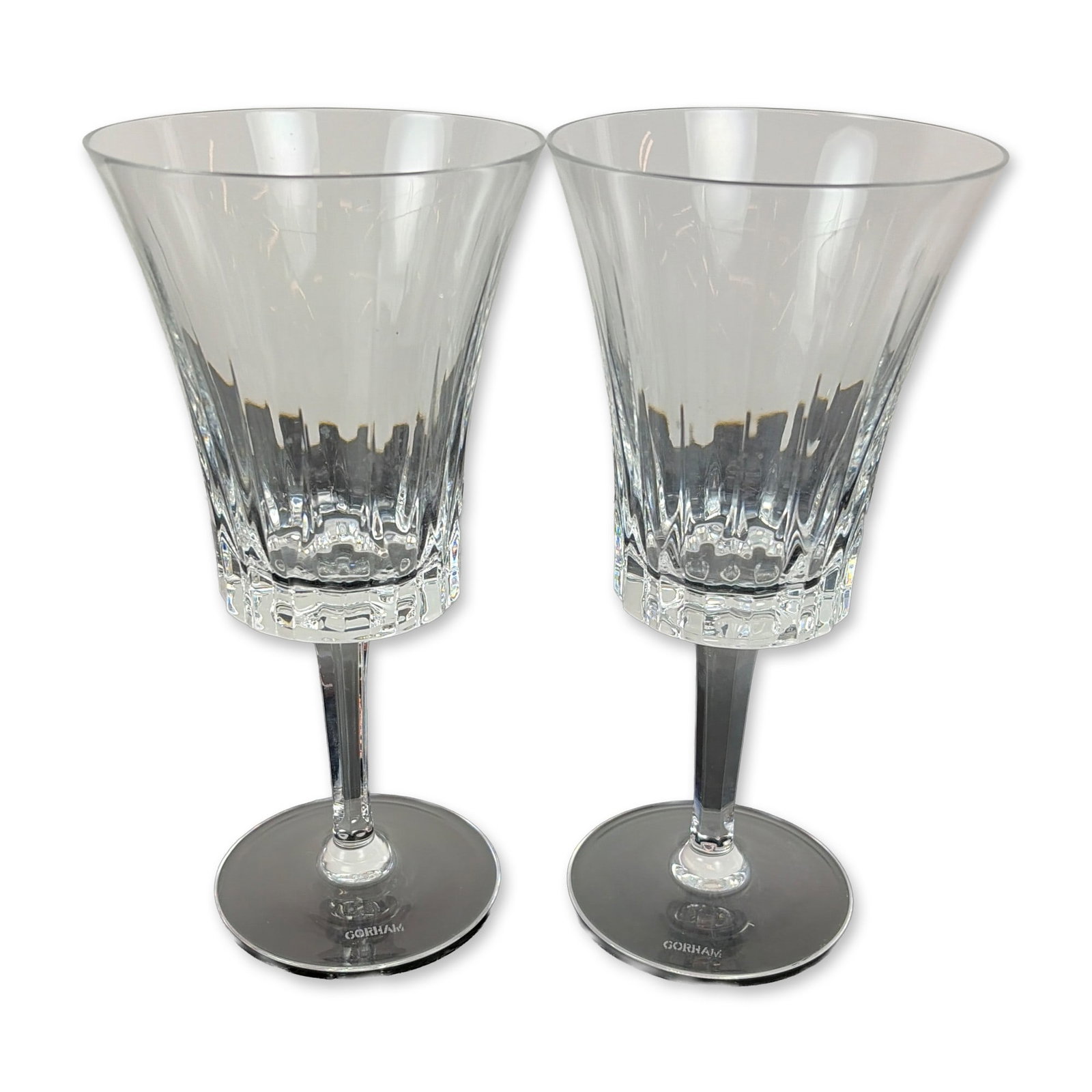 Pair of Gorham Richelieu-Rondo Water Goblets: Each vessel features a trumpet-shaped flared bowl decorated with vertical fluted cuts above a band of deep crisscross diamond accents. The stems are faceted and taper toward a circular foot. The foot 