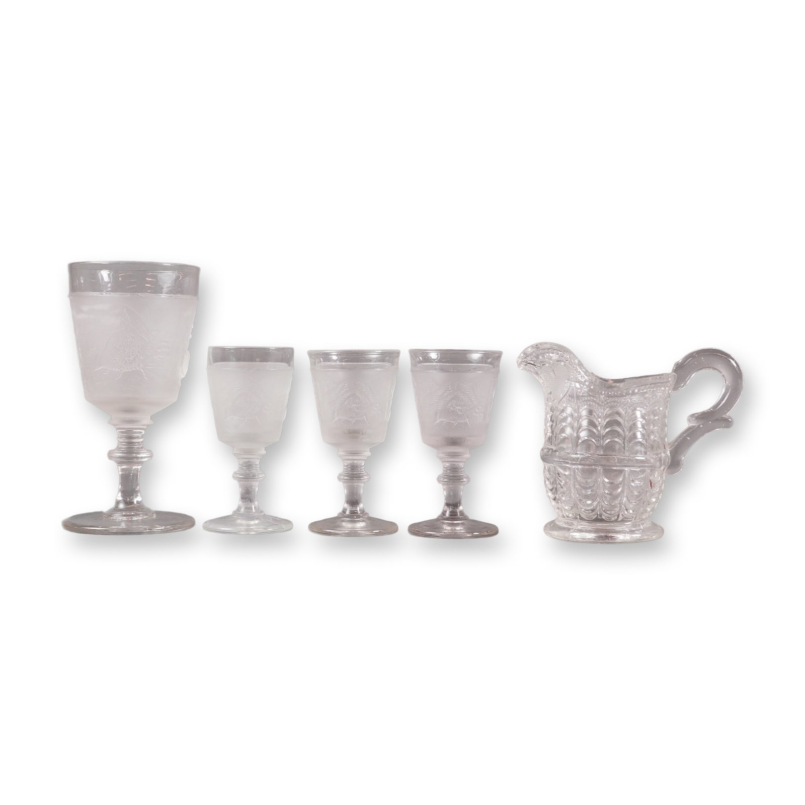 A Collection of 5 EAPG Pressed Glass Cups and Pitcher: A collection of five pieces of Early American Pressed Glass EAPG, comprising four stemmed drinking glasses and one handled creamer. The four stemmed glasses, one wine glass and three smaller cordial g