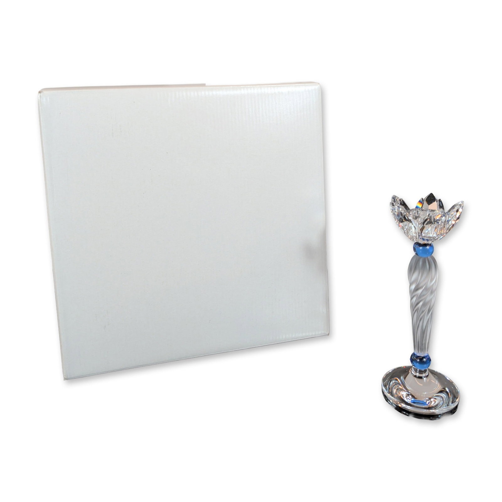 Swarovski Crystal Blue Flower Candleholder: Swarovski lead crystal candlestick in the Blue Flower pattern, featuring a faceted clear crystal cup in the form of an opening blossom. The frosted, twisted crystal stem is punctuated by two transluce