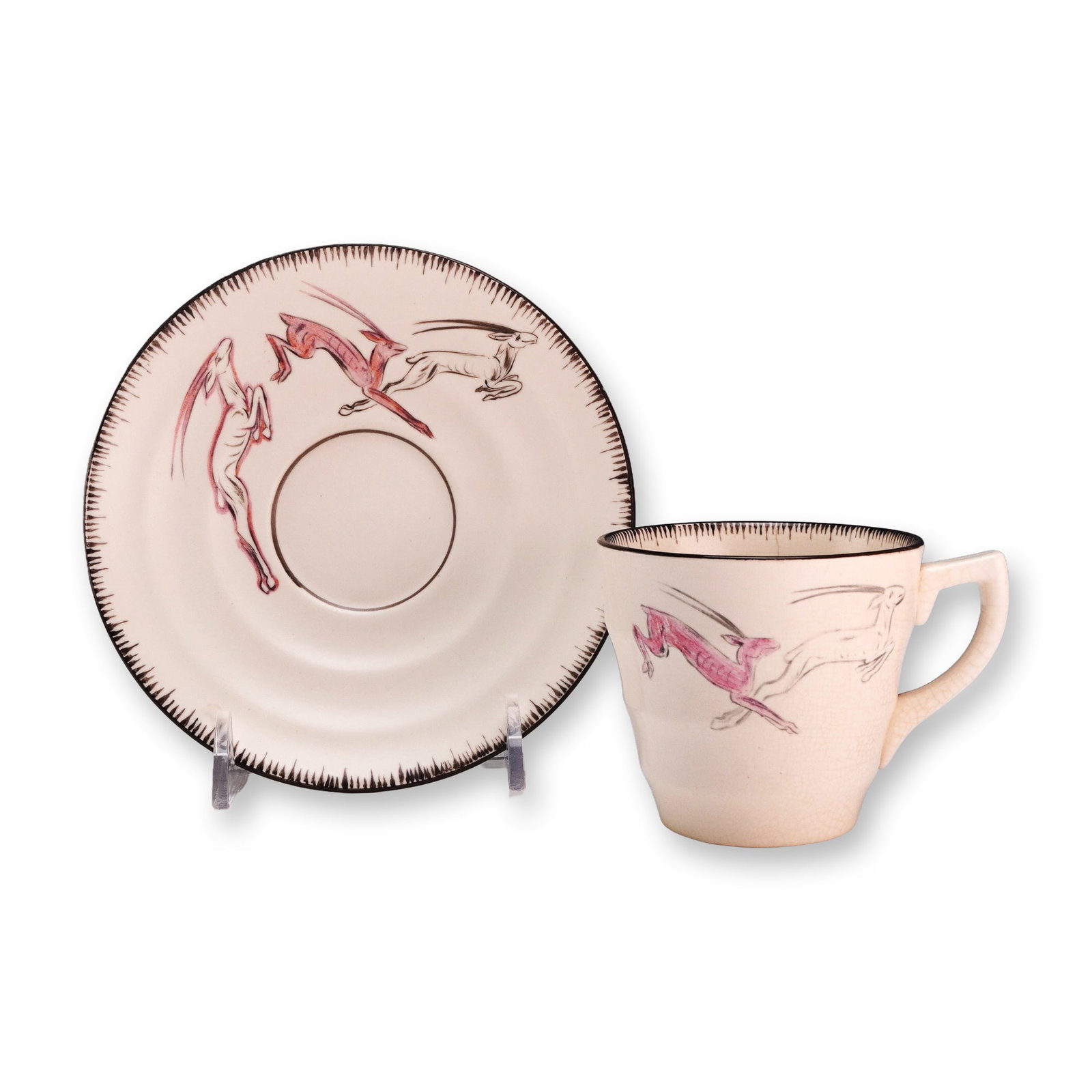 Wedgwood by Jean Knowles Moonstone Earthenware Teacup and Saucer Set, 1937: A two-piece teacup and saucer set manufactured by Wedgwood in the Moonstone earthenware line. The set features a matte white glaze and is decorated with hand-painted stylized leaping gazelles or antel