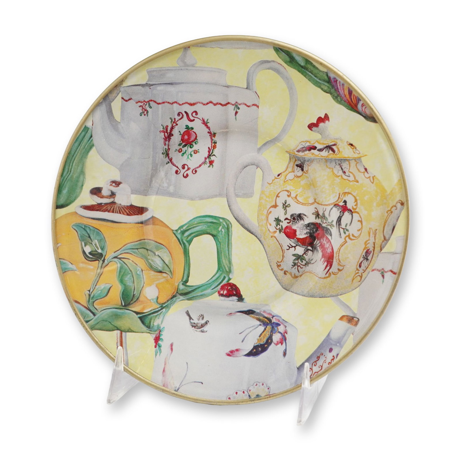 Marie Murray Handcrafted Decoupage Teapot Decorative Plate: This decorative plate by Marie Murray of New Orleans, Louisiana features a handcrafted decoupage motif sealed under a clear finish. The design presents a collage of various teapot forms adorned with