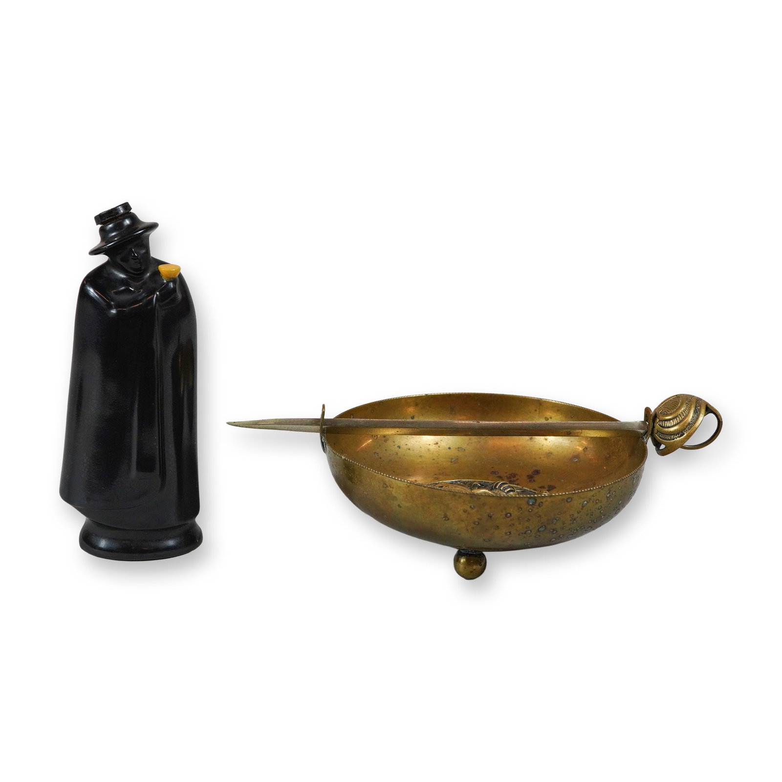 Two Piece Lot including Royal Doulton Sandeman Don Sherry Bottle and Brass Heraldic Bowl with: This lot consists of two decorative objects including a Royal Doulton figural bottle and a brass heraldic crumb bowl. The glazed ceramic bottle is modeled as the Sandeman Don, the iconic advertising m