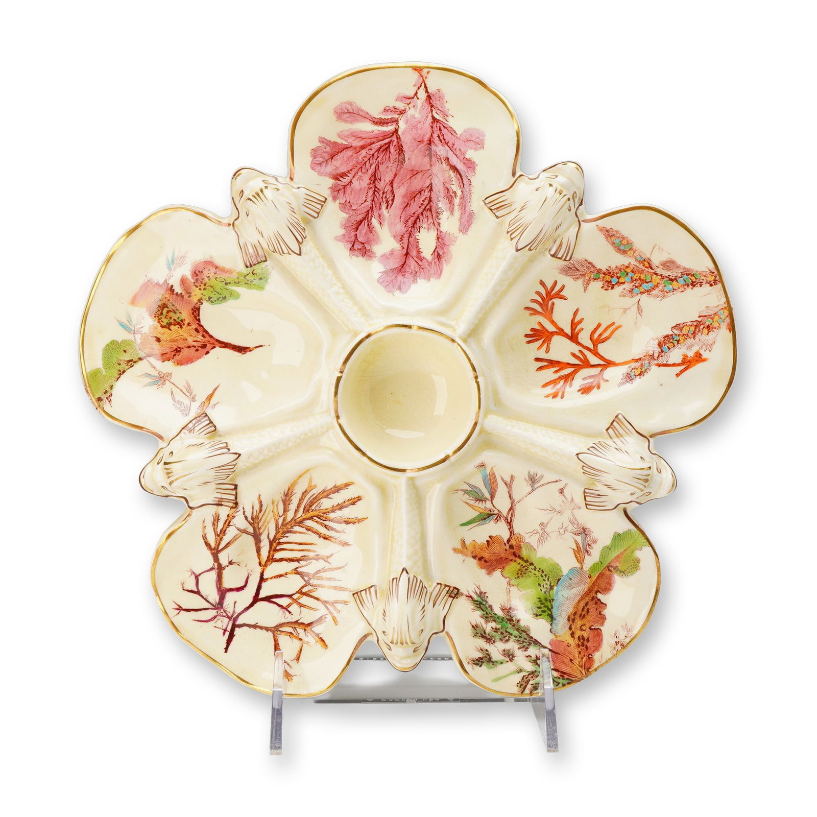 Wedgwood Scallop and Seaweed Majolica Oyster Plate: This Victorian era glazed earthenware oyster plate is a product of the renowned English firm Wedgwood, featuring the popular Scallop and Seaweed pattern. The plate is designed with five scallop-shell-