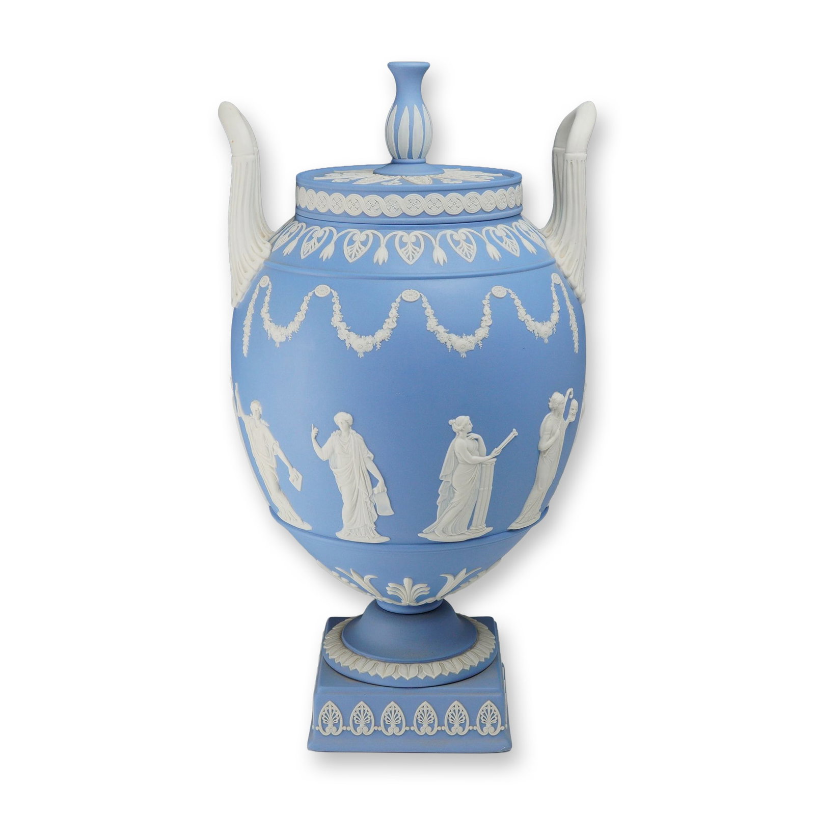 Large Wedgwood Pale Blue Jasperware Lidded Urn on Plinth: This large Wedgwood lidded urn is crafted from pale blue jasperware stoneware and set upon a separate matching square plinth base. The vessel features a classic ovoid body flanked by two high-arching,