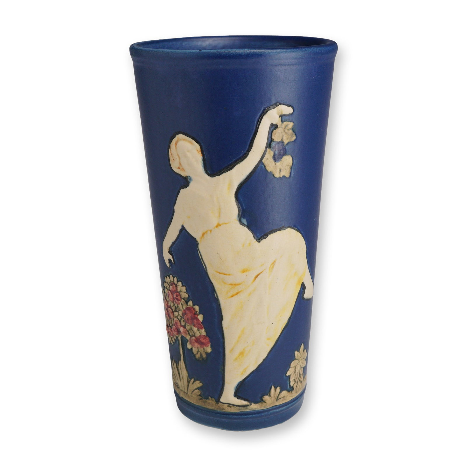 Weller Pottery Blue Ware Vase, Lady Dancing in a Garden: Blue Ware ceramic vase featuring a tapered cylindrical form. The exterior is finished in a matte cobalt blue glaze and decorated with sprigged relief motifs in cream, pink, and tan tones. The decorati