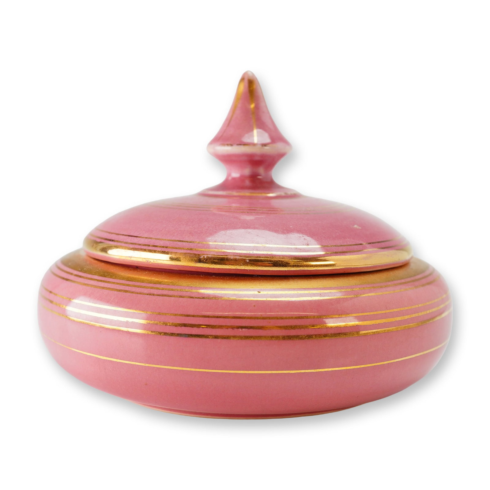 Weller Pottery Covered Powder Vanity Jar: The piece features a squat, rounded form and a coordinating domed lid topped with a pointed finial. The exterior is finished in a vibrant rose-pink glaze, accented by multiple concentric horizontal go