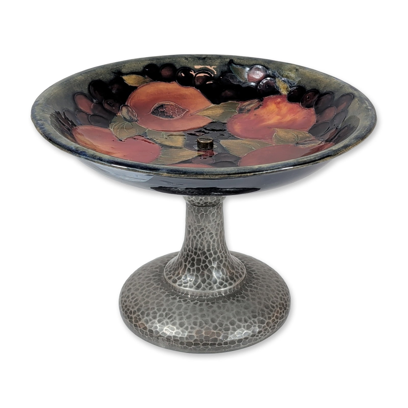 Moorcroft Pomegranate Tudric Pewter Tazza: Moorcroft Pomegranate pattern tazza, circa 1928, featuring a tubelined earthenware bowl mounted on a hammered Tudric pewter pedestal base. The interior of the bowl is decorated with hand-painted