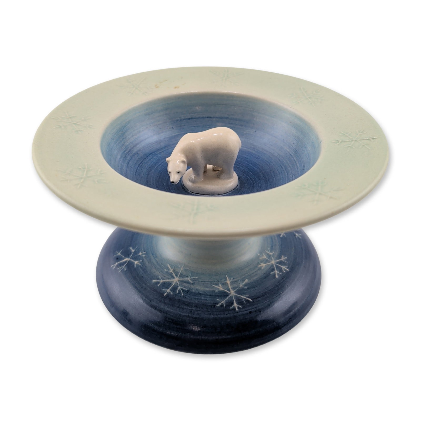 Dennis Chinaworks by Sally Tuffin Polar Bear Pedestal Bowl: The piece features a shallow flared bowl with a central three-dimensional figure of a polar bear, set against a graduated blue and pale green ground. Hand-painted white snowflake motifs decorate the i