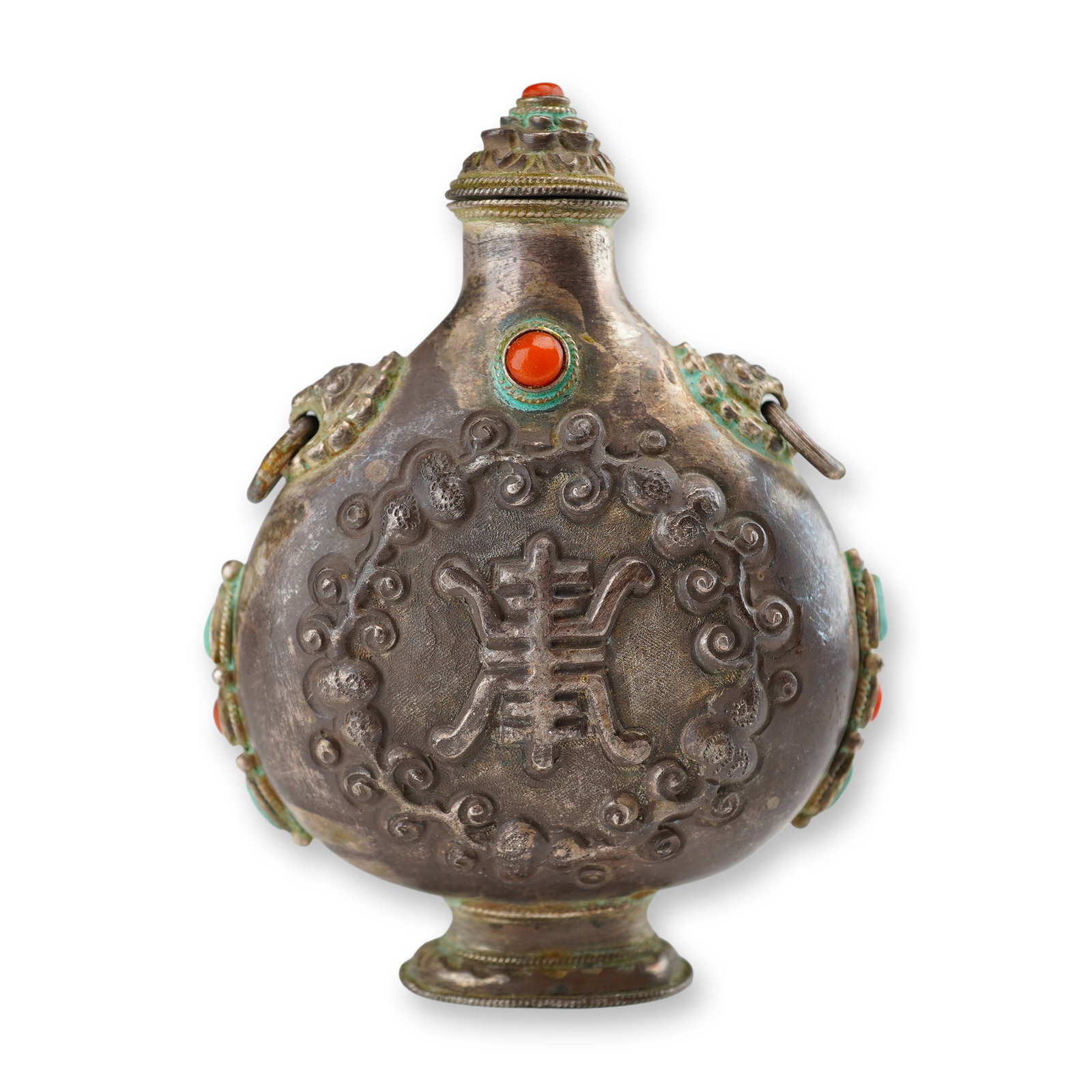 Mongolian Silver Repousse Snuff Bottle, Shou Symbol, Lion Handles: This Mongolian silver repousse snuff bottle with stopper features the Shou symbol surrounded by a scroll-like design, accented by lion head handles, and embellished with coral and turquoise stones. Di