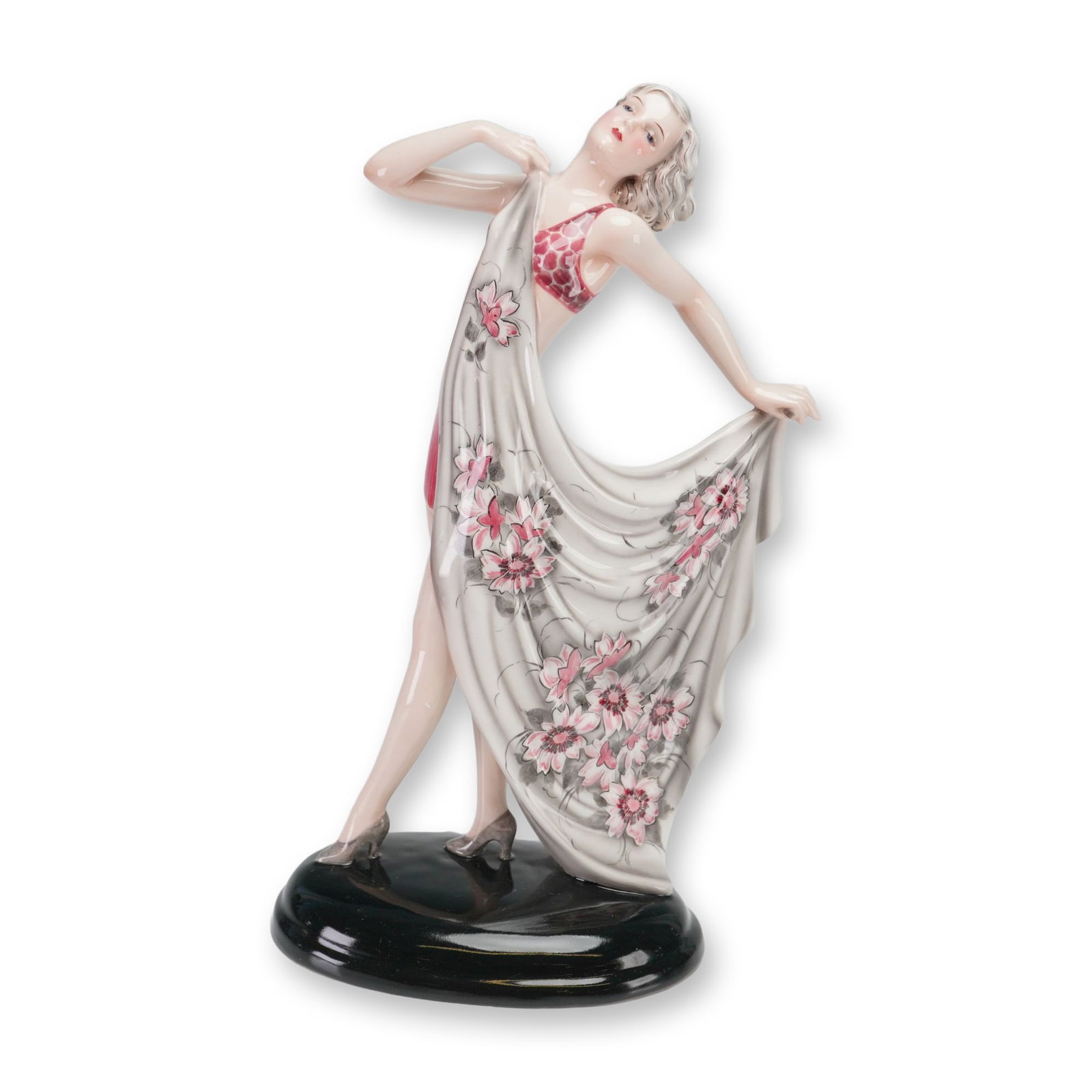 Goldscheider Stefan Dakon Art Deco Dancer Figurine, 8472: Art Deco polychrome glazed earthenware figure of a stylized female in a dynamic pose. She wears a dark pink patterned two-piece bathing suit and holds a draped wrap with pink and white floral motifs o