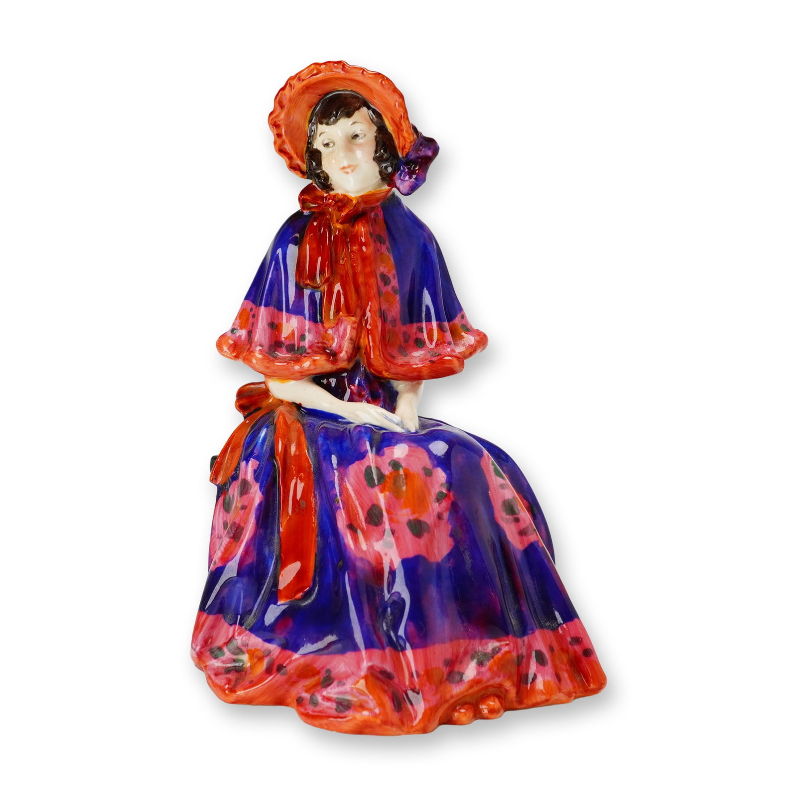 Royal Doulton Porcelain Figurine, Rosina HN1364: Designed by Leslie Harradine. The figure depicts a seated woman in stylized historical attire, featuring a wide-brimmed red bonnet with purple ribbon and a vibrant blue and red patterned gown with a s