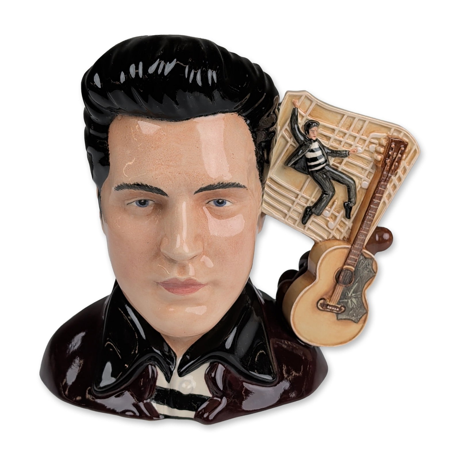 Royal Doulton Prototype Large Character Jug Elvis Presley: Royal Doulton glazed ceramic character jug depicting Elvis Presley. The bust features a dark burgundy stage jacket and a black pompadour hairstyle. The handle incorporates thematic elements from Presl