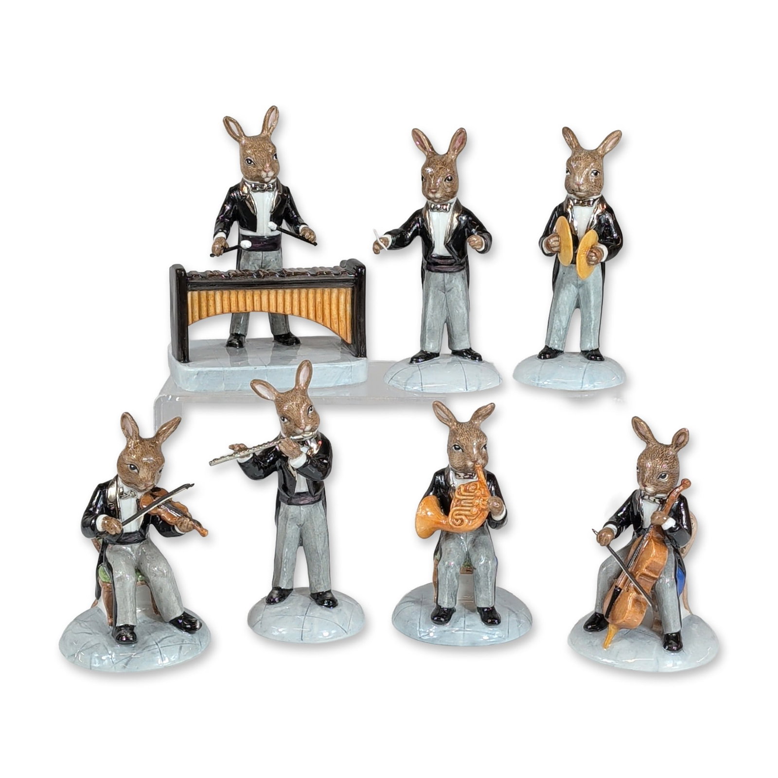 Royal Doulton Bunnykins Orchestra Limited Edition Figurine Set: Royal Doulton (England). Seven hand-painted porcelain figurines from the Bunnykins Orchestra series. Each figure depicts an anthropomorphic rabbit in formal evening attire, featuring black tailcoats, 