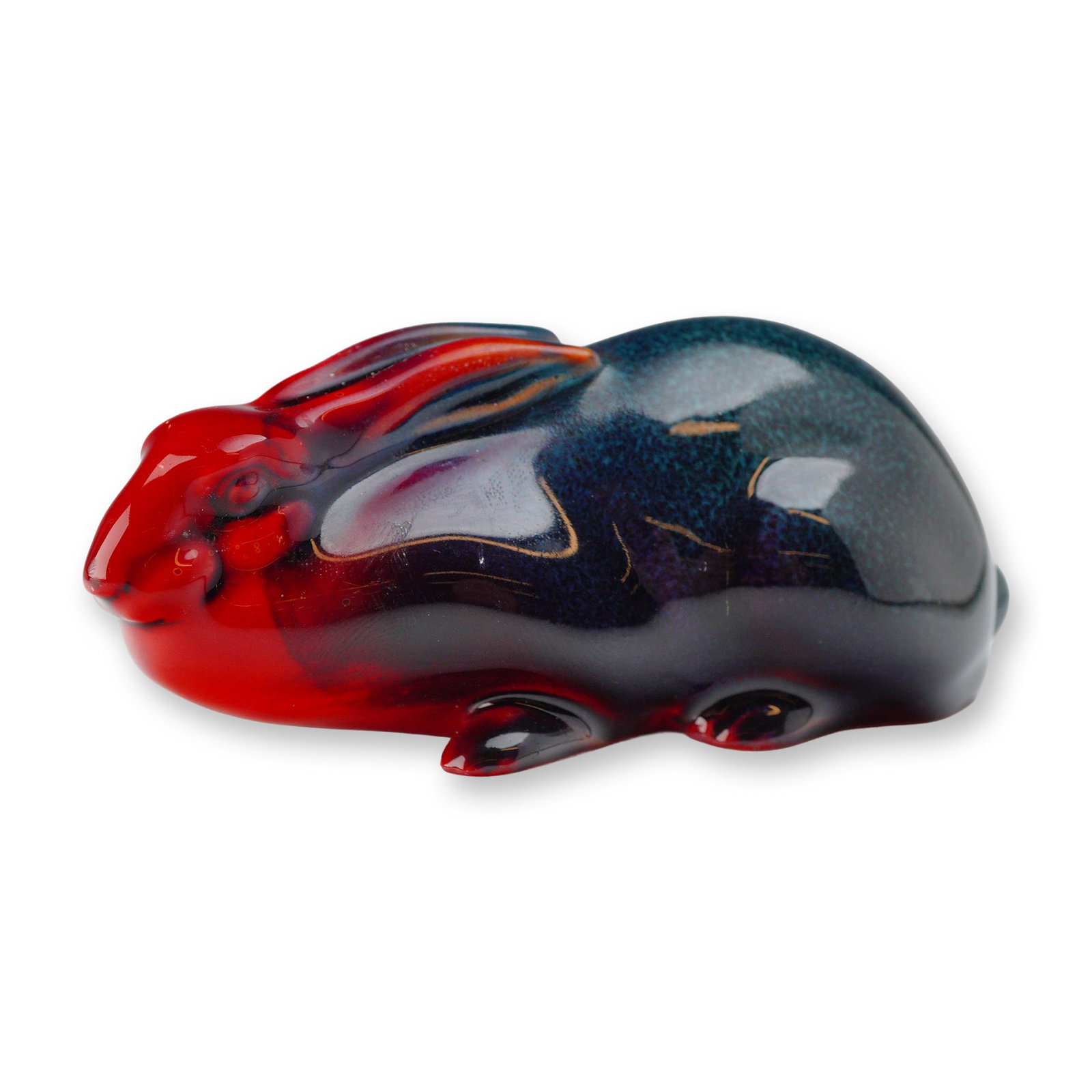 Royal Doulton Flambe Bone China Rabbit Figurine: A single Royal Doulton Flambe Bone China Figurine, sculpted in the form of a recumbent rabbit or hare. The piece is finished with a highly glossy, transitional glaze, characteristic of the Flambe tech