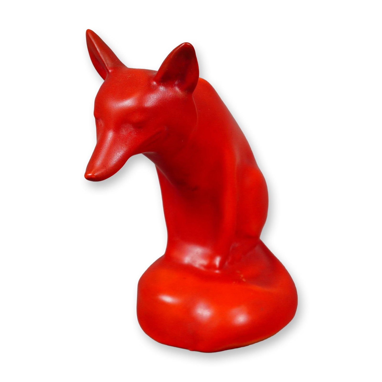 Rare Royal Doulton Red Experimental Glaze Figurine, Fox Seated: A porcelain figure of a seated fox perched on a rock, its tail elegantly curled around the front. The piece is finished in a rich red satin glaze, with an unglazed base revealing the Royal Doulton bac