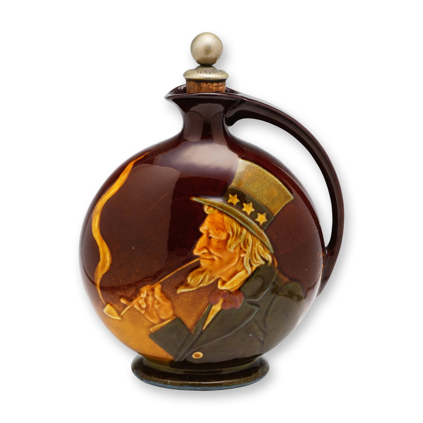 Royal Doulton Dewar's Scotch Whisky Kingsware Flask, Uncle Sam: Kingsware Jug with Uncle Sam on one side, dressed in a suit and smoking a long tobacco pipe and on the other side is Dewar's Scotch Whiskey. Royal Doulton backstamp. Dimensions: 6.5"L x 3"W x 8.75"H M